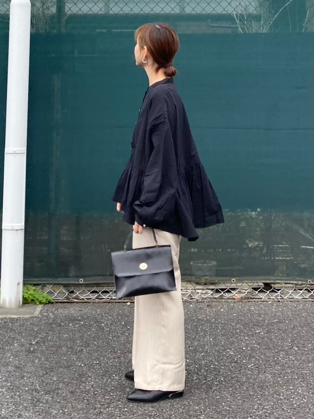ブラック系のシャツ/ブラウス、ホワイト系のその他パンツ、ブラック系のショルダーバッグを着用したレディースの春コーディネートの2枚目の写真