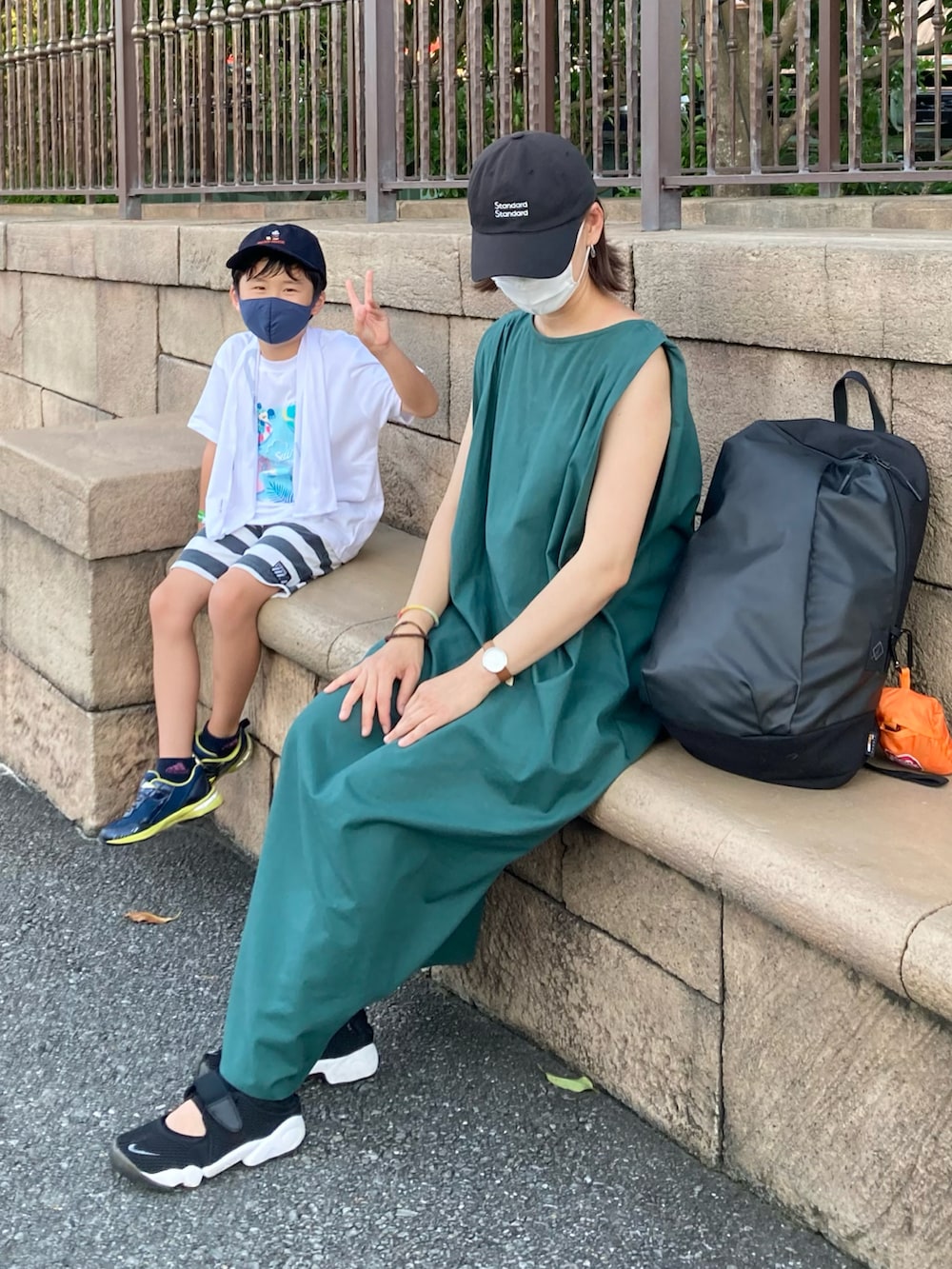 グリーン系のワンピース、ブラック系のバックパック/リュック、ブラック系のスニーカーを着用したレディースの夏コーディネートの2枚目の写真