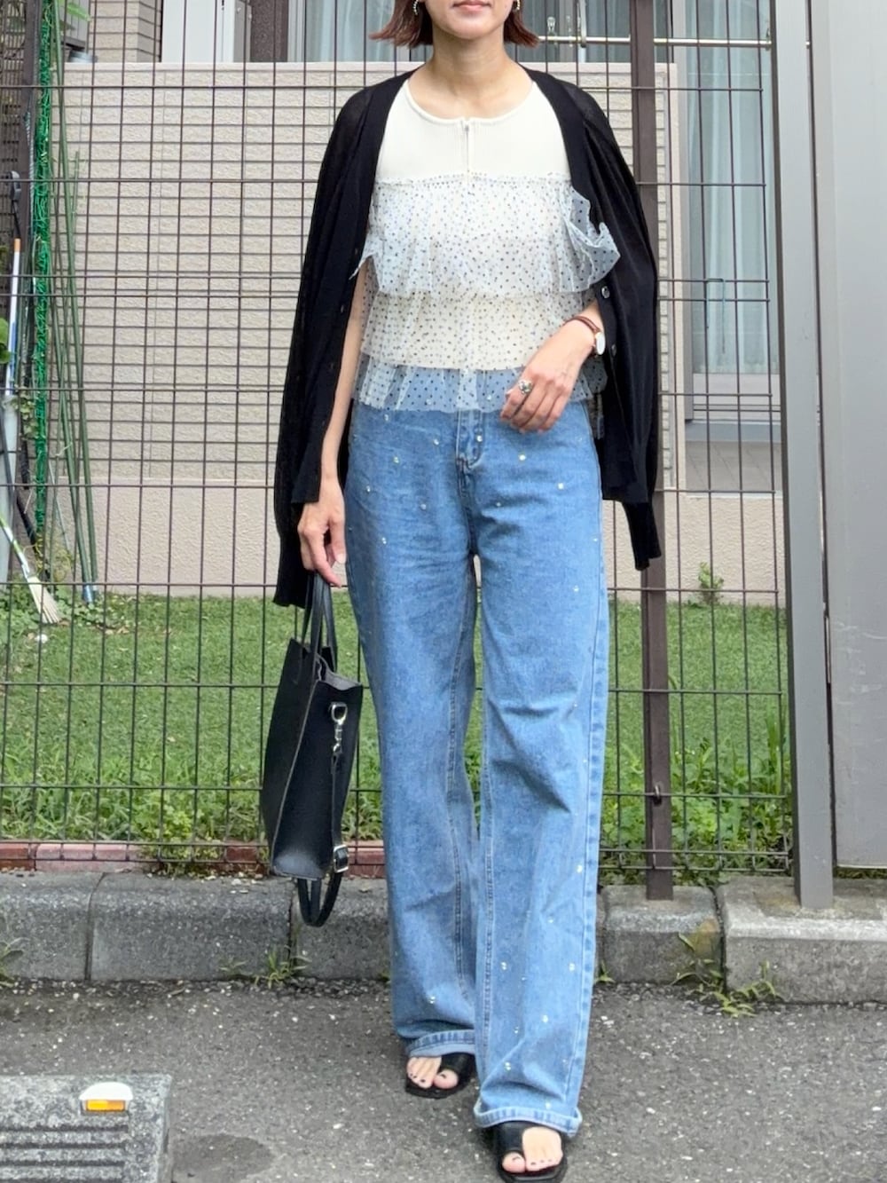 ホワイト系のニット/セーター、ブラック系のショルダーバッグ、ブラック系のカーディガン/ボレロを着用したレディースの夏コーディネートの2枚目の写真