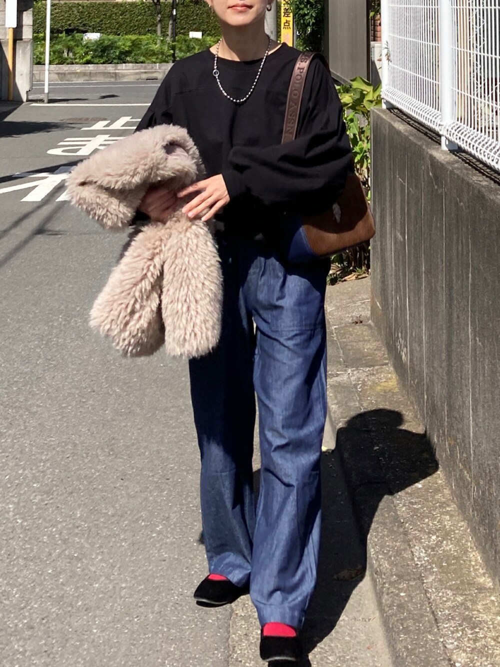 ブラック系のTシャツ/カットソー、ブルー系のその他パンツ、ブラウン系のショルダーバッグを着用したレディースの秋コーディネートの4枚目の写真