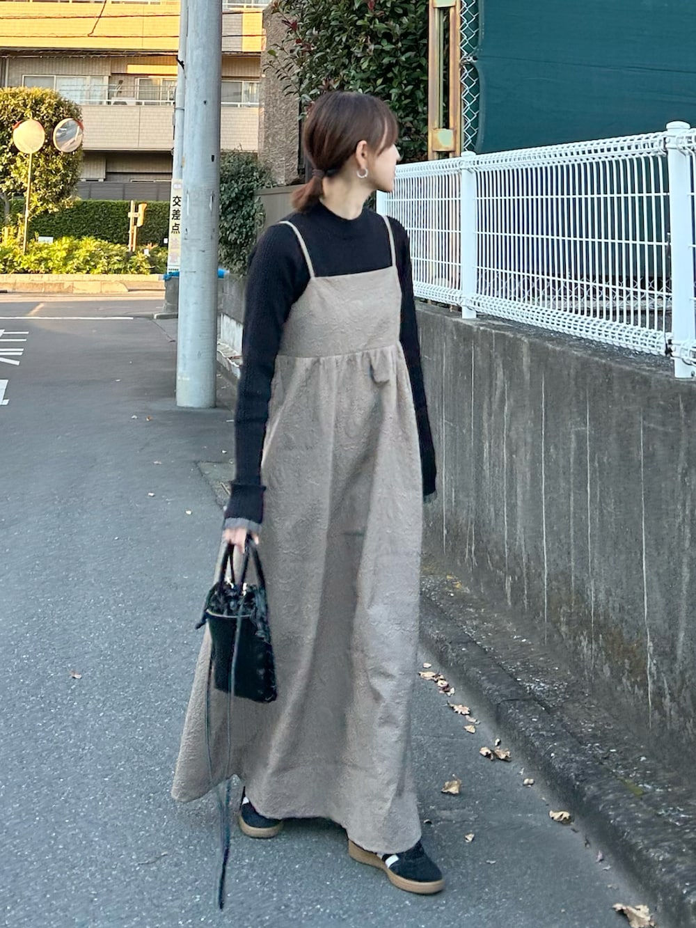 ベージュ系のワンピース、ブラック系のショルダーバッグを着用したレディースの冬コーディネートの2枚目の写真