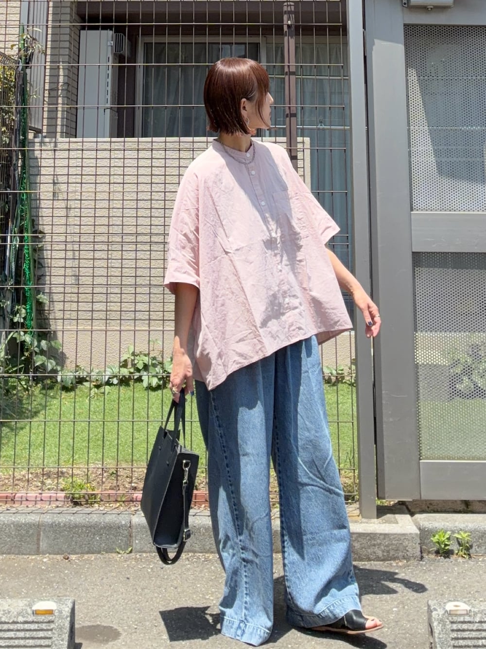 ピンク系のシャツ/ブラウス、ブルー系のデニムパンツ、ブラック系のショルダーバッグを着用したレディースの春コーディネートの2枚目の写真