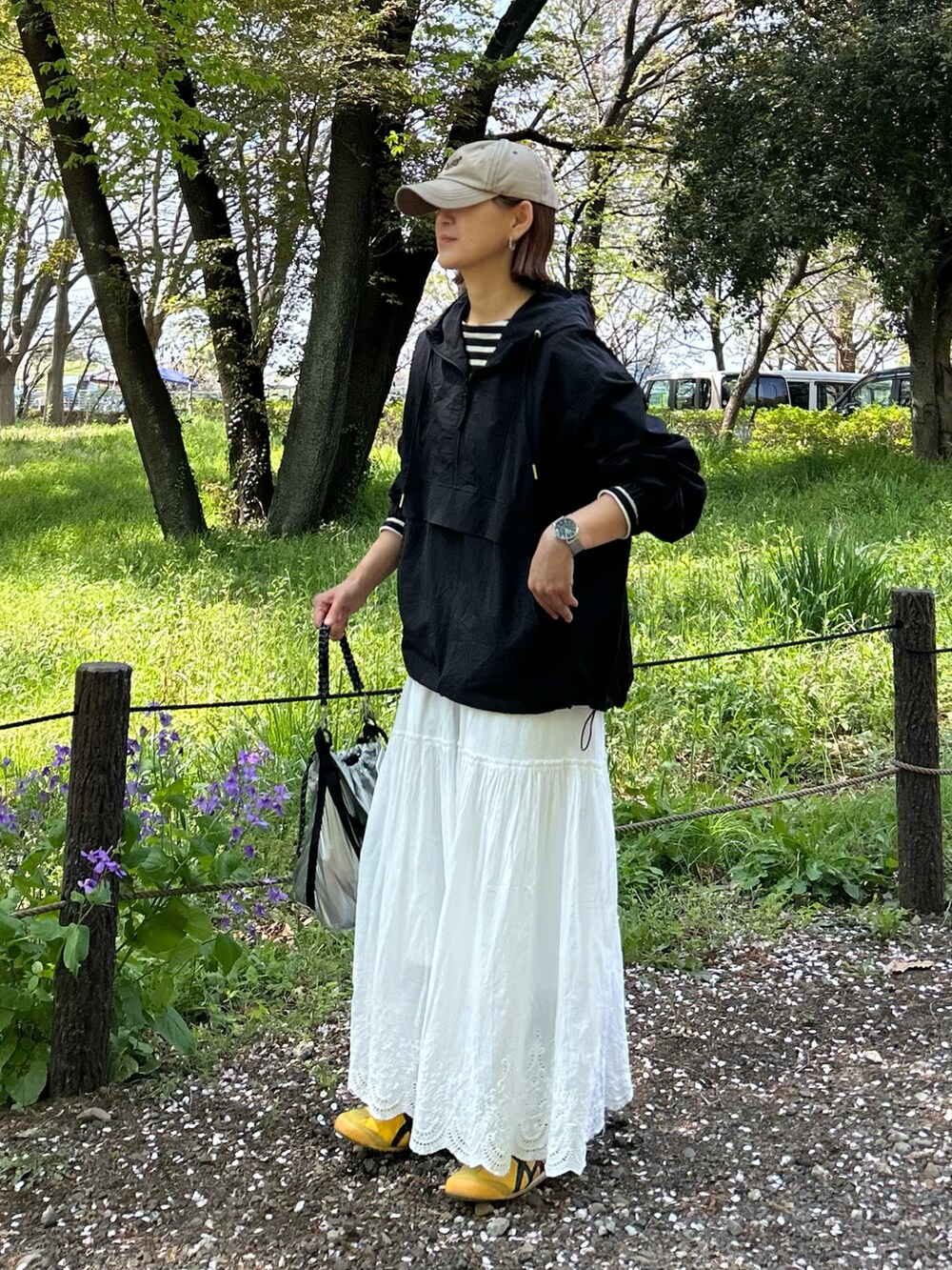 ブラック系のブルゾン、ブラック系のTシャツ/カットソー、ホワイト系のスカートを着用したレディースの春コーディネートの2枚目の写真