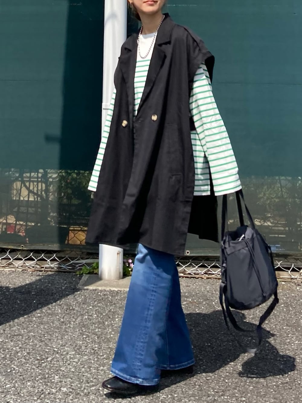 グリーン系のTシャツ/カットソー、ブラック系のその他アウター、ブルー系のデニムパンツを着用したレディースの春コーディネートの5枚目の写真