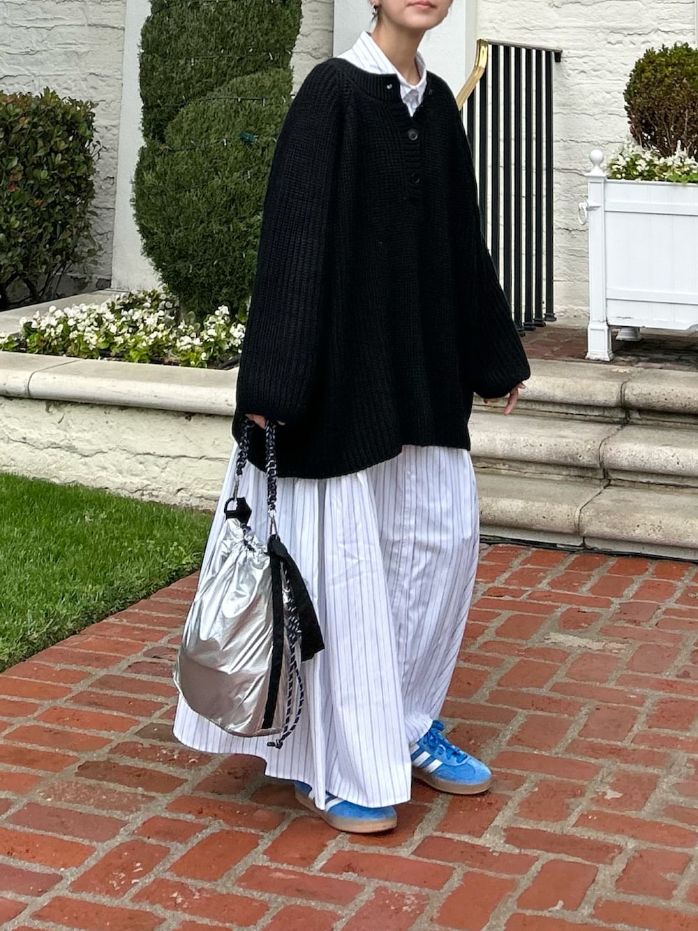 ブラック系のニット/セーター、ホワイト系のシャツワンピース、シルバー系のトートバッグを着用したレディースの冬コーディネートの2枚目の写真