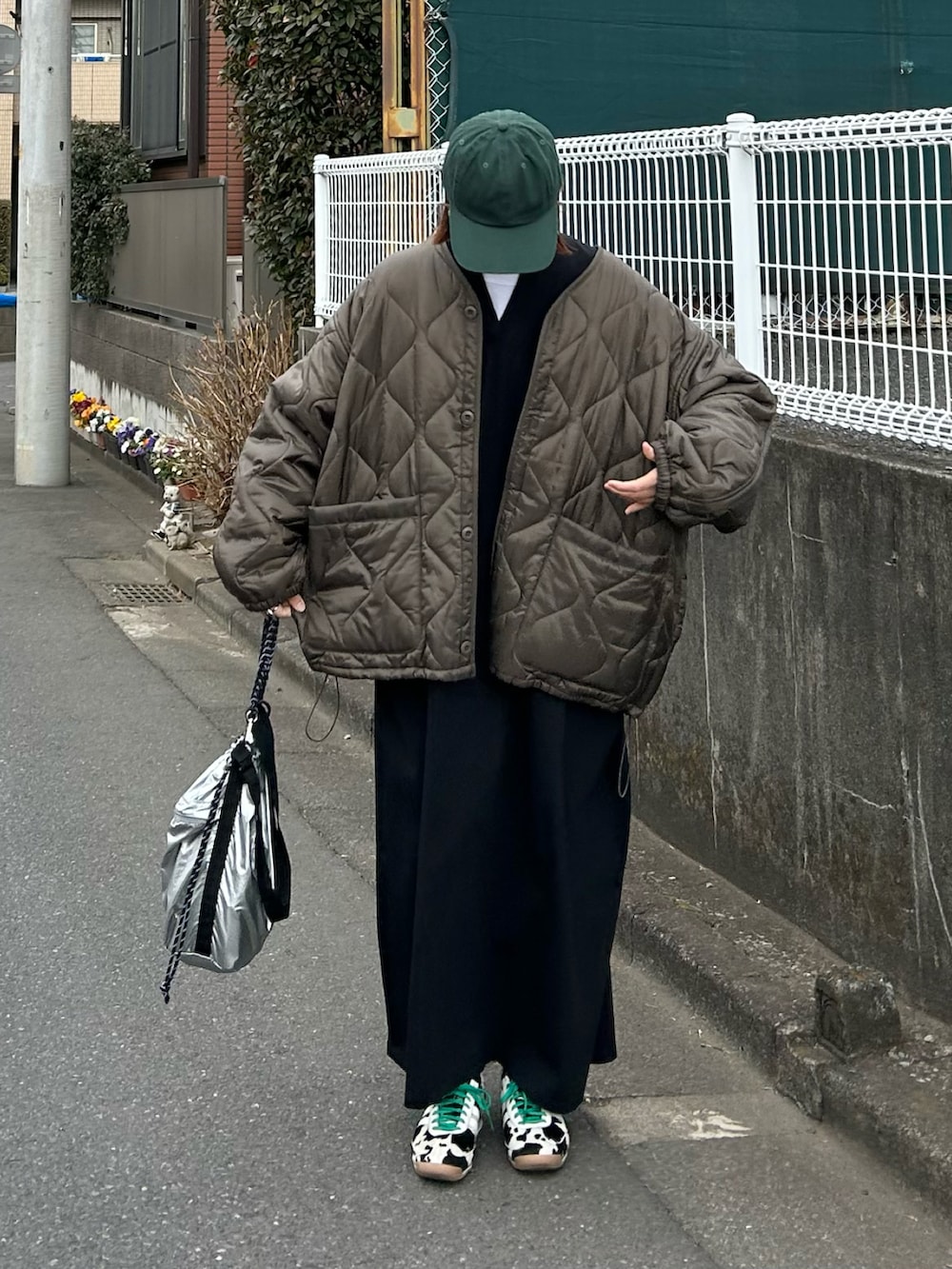 ブラウン系のブルゾン、シルバー系のトートバッグ、ブラック系のスニーカーを着用したレディースの冬コーディネートの4枚目の写真