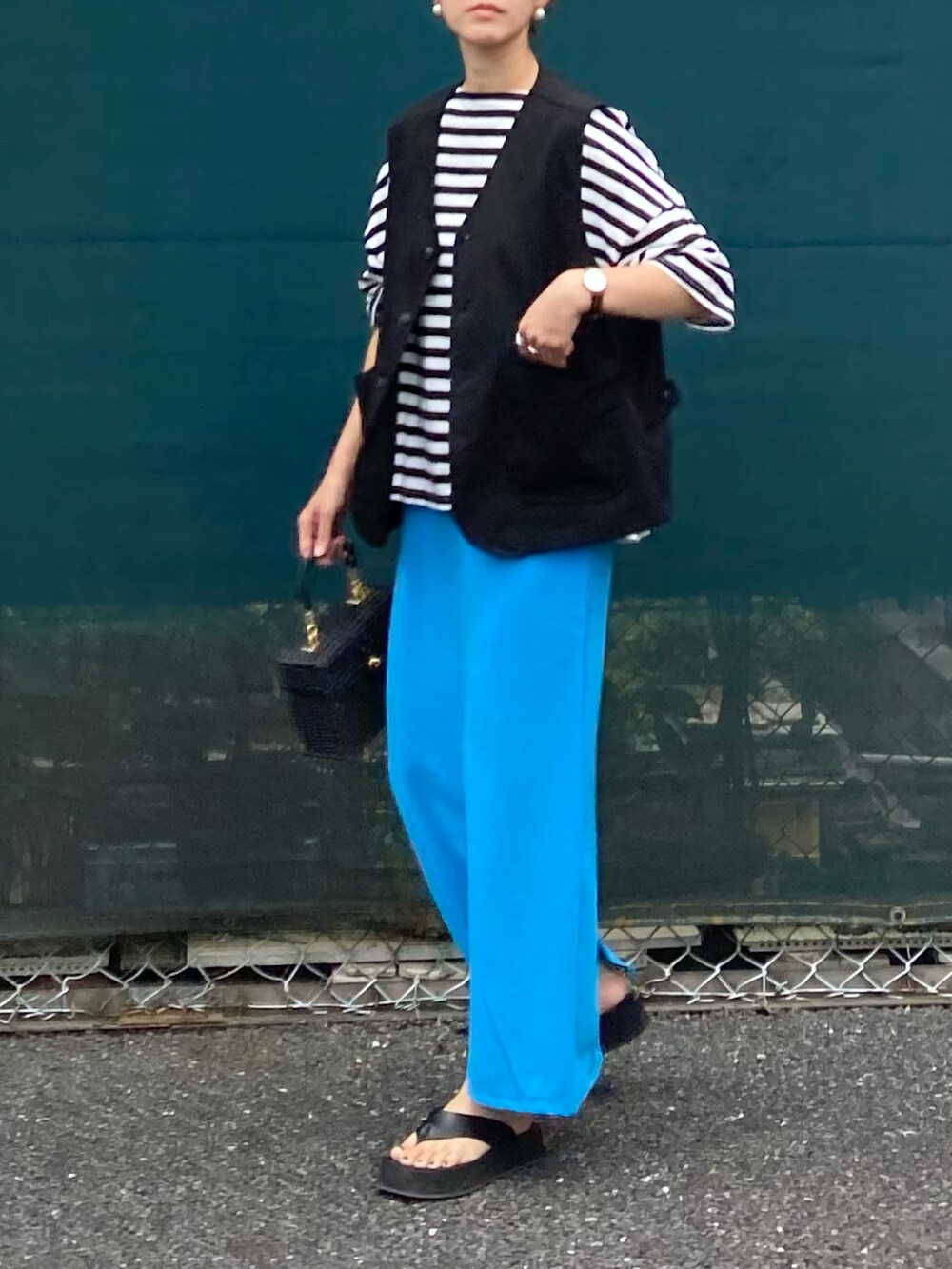 ブラック系のベスト、ブラック系のTシャツ/カットソー、ブルー系のスカートを着用したレディースの夏コーディネートの3枚目の写真