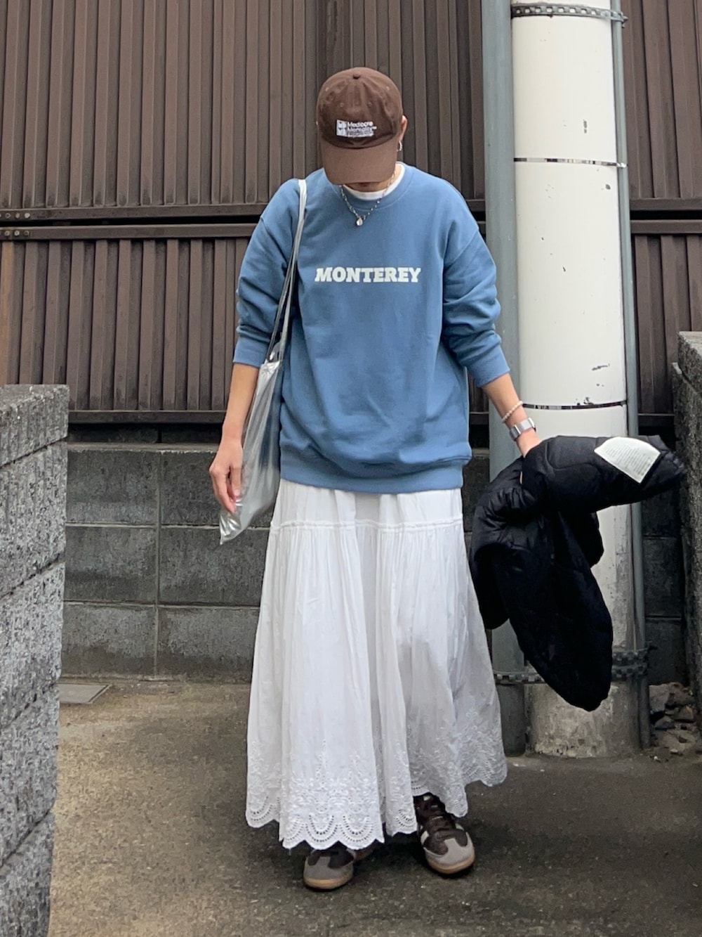 ブルー系のスウェット、ホワイト系のスカート、ブラック系のブルゾンを着用したレディースの冬コーディネートの2枚目の写真