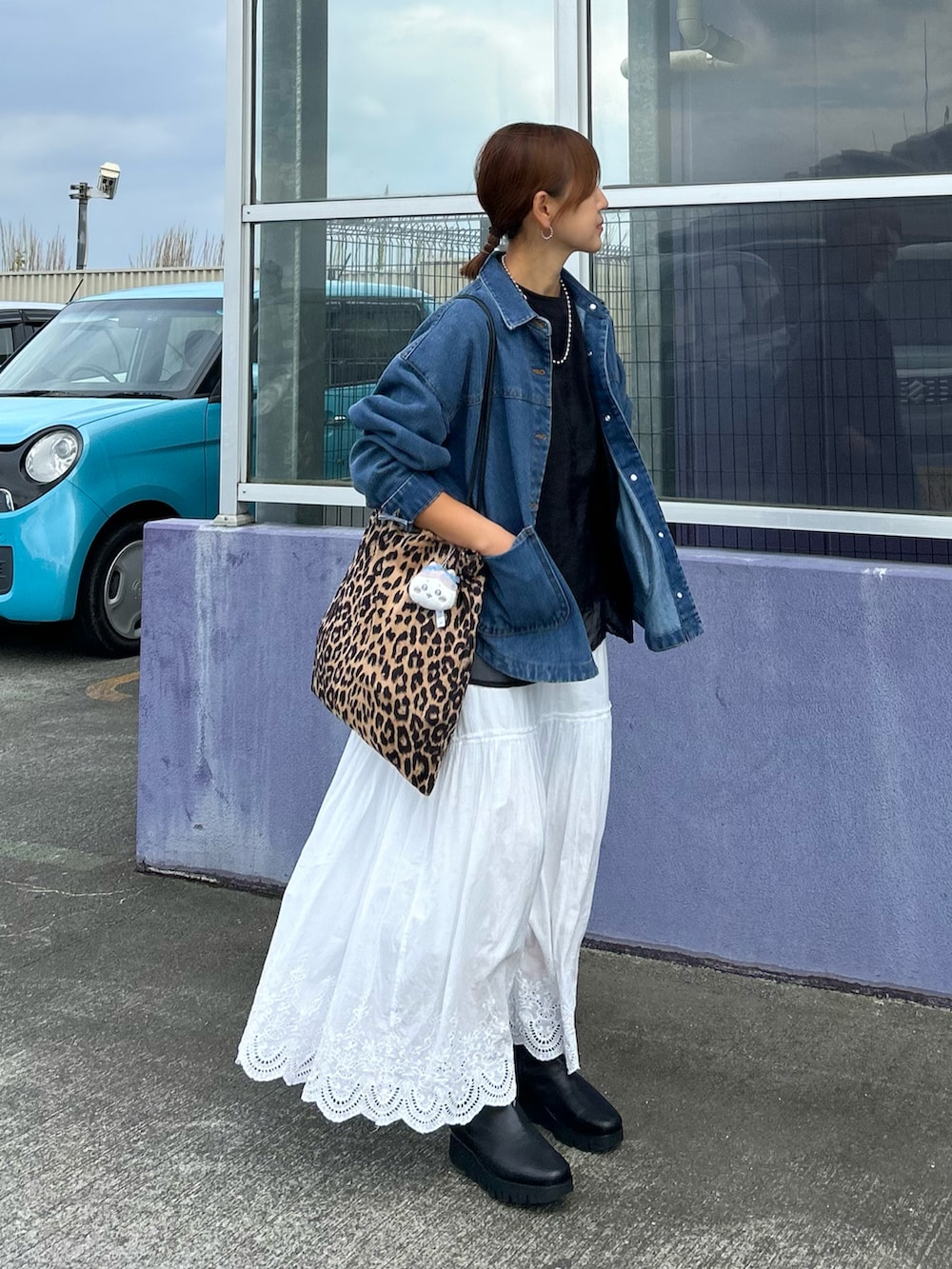 ホワイト系のスカート、ブルー系のデニムジャケット、ブラウン系のトートバッグを着用したレディースの秋コーディネートの2枚目の写真