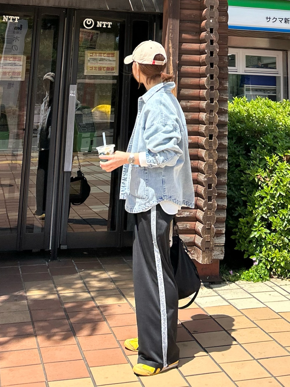 ブルー系のデニムジャケット、ホワイト系のシャツ/ブラウス、ブラック系のスラックスを着用したレディースの春コーディネートの2枚目の写真