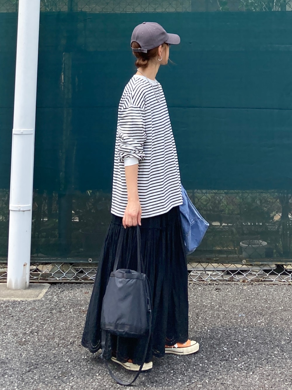 ホワイト系のTシャツ/カットソー、ブラック系のスカート、ブラック系のバッグを着用したレディースの夏コーディネートの3枚目の写真