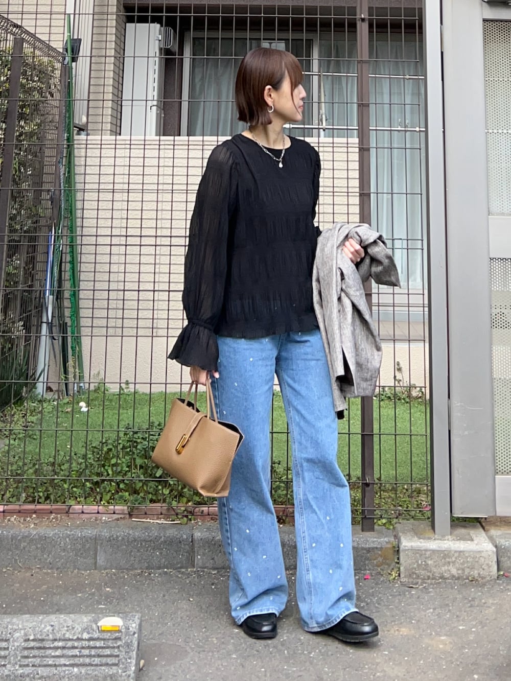 ブラック系のシャツ/ブラウス、ベージュ系のテーラードジャケット、ブラウン系のハンドバッグを着用したレディースの冬コーディネートの4枚目の写真