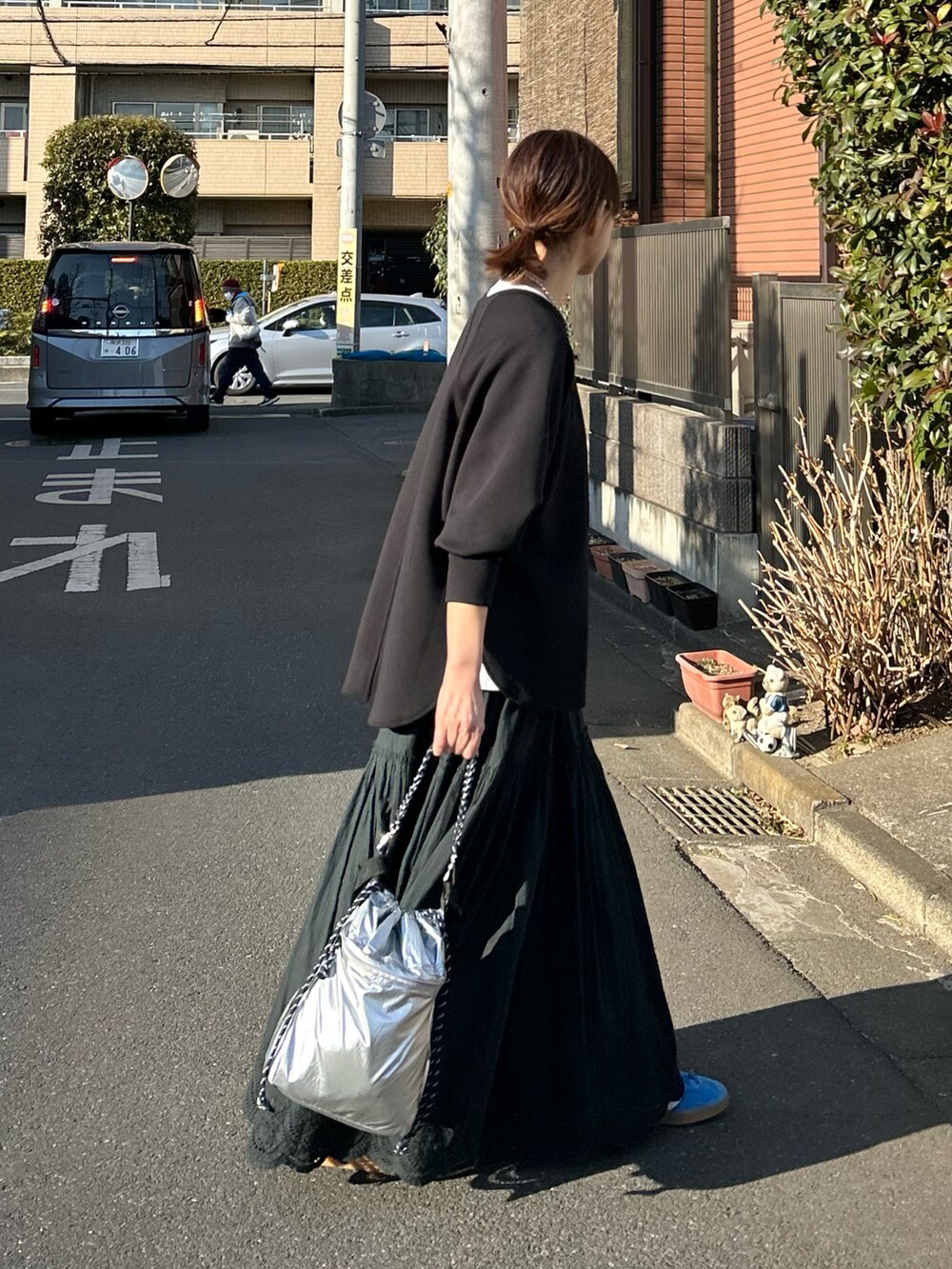 ブラック系のTシャツ/カットソー、ブラック系のスカート、シルバー系のショルダーバッグを着用したレディースの冬コーディネートの3枚目の写真
