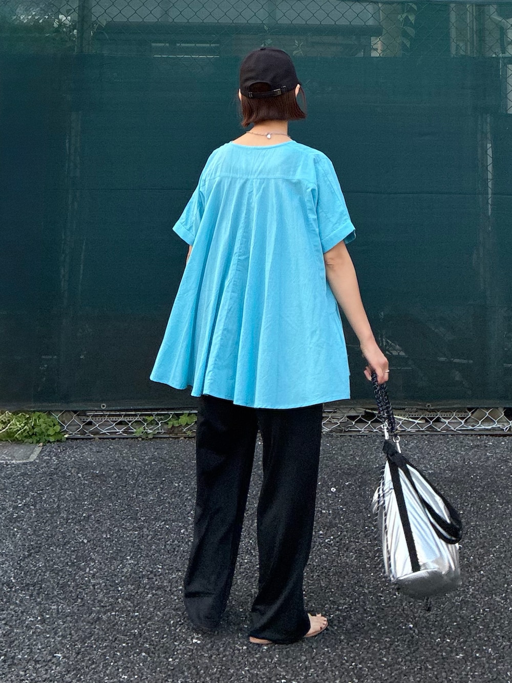 ブルー系のシャツ/ブラウス、ブラック系のスラックス、シルバー系のショルダーバッグを着用したレディースの夏コーディネートの3枚目の写真