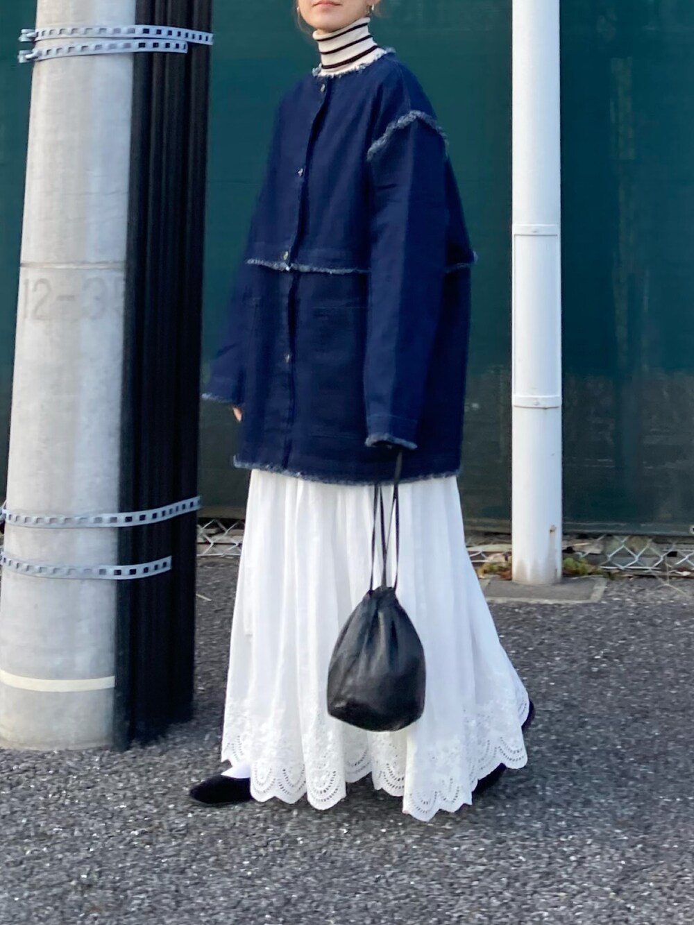 ブルー系のデニムジャケット、ホワイト系のスカート、ホワイト系のニット/セーターを着用したレディースの冬コーディネートの4枚目の写真