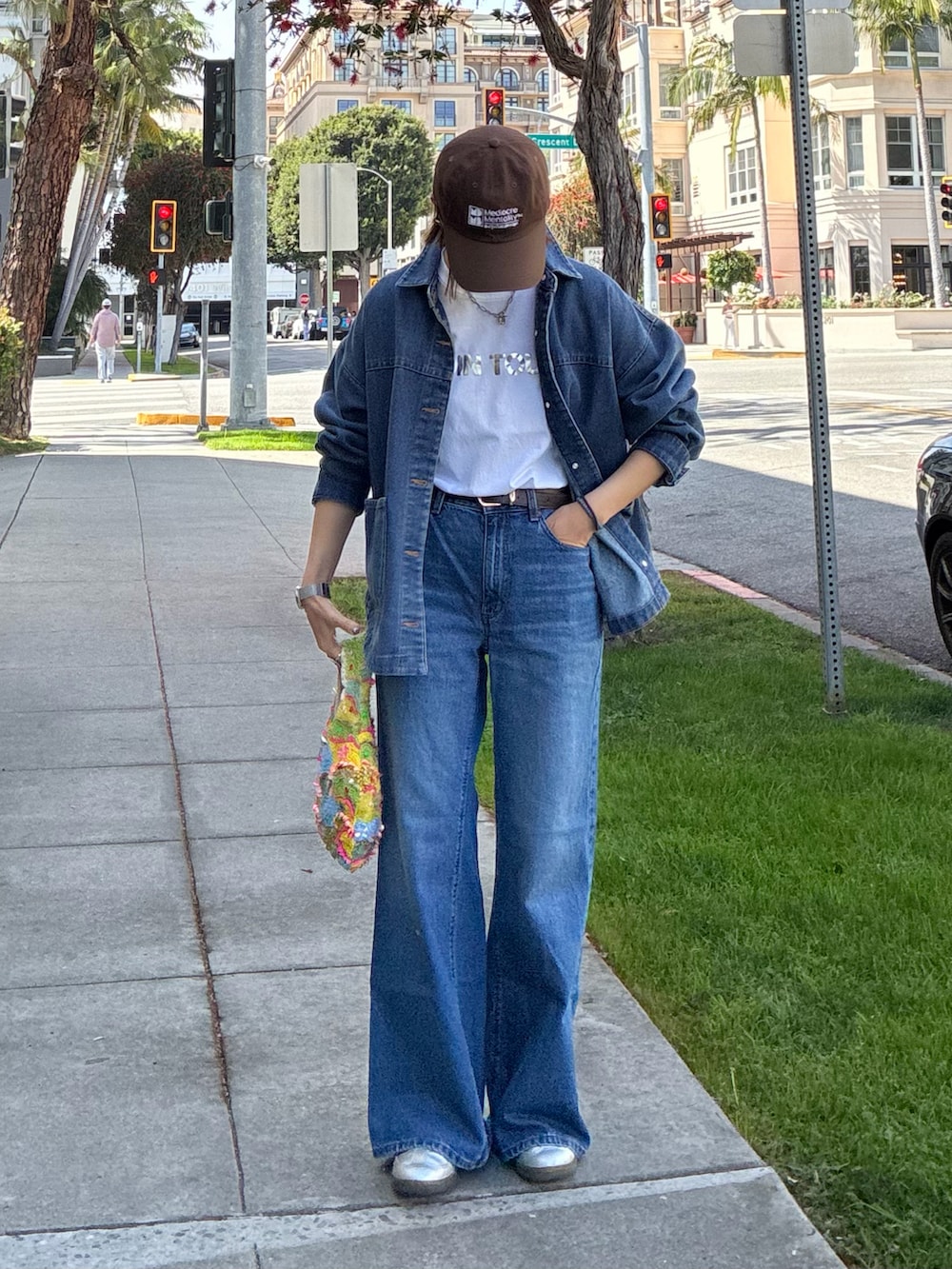 ブルー系のデニムジャケット、シルバー系のスニーカー、ホワイト系のTシャツ/カットソーを着用したレディースの春コーディネートの3枚目の写真