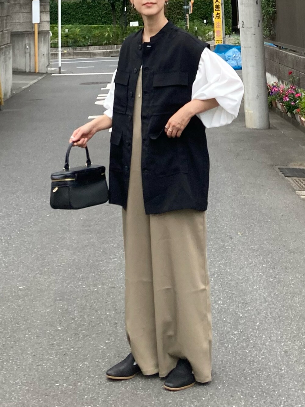 ブラック系のシャツ/ブラウス、ベージュ系のサロペット/オーバーオール、ホワイト系のシャツ/ブラウスを着用したレディースの夏コーディネートの3枚目の写真