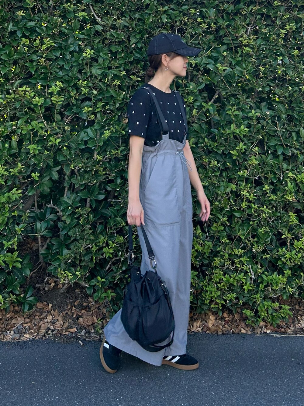 ブラック系のTシャツ/カットソー、グレー系のジャンパースカート、ブラック系のショルダーバッグを着用したレディースの夏コーディネートの3枚目の写真