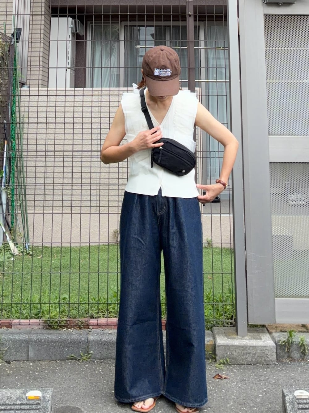 ブラック系のボディバッグ/ウエストポーチ、ホワイト系のカーディガン/ボレロ、ブルー系のデニムパンツを着用したレディースの夏コーディネートの2枚目の写真
