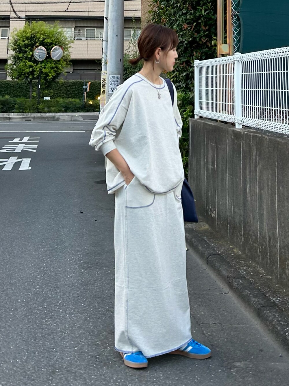 ベージュ系のTシャツ/カットソー、ベージュ系のスカート、ブルー系のトートバッグを着用したレディースの秋コーディネートの3枚目の写真