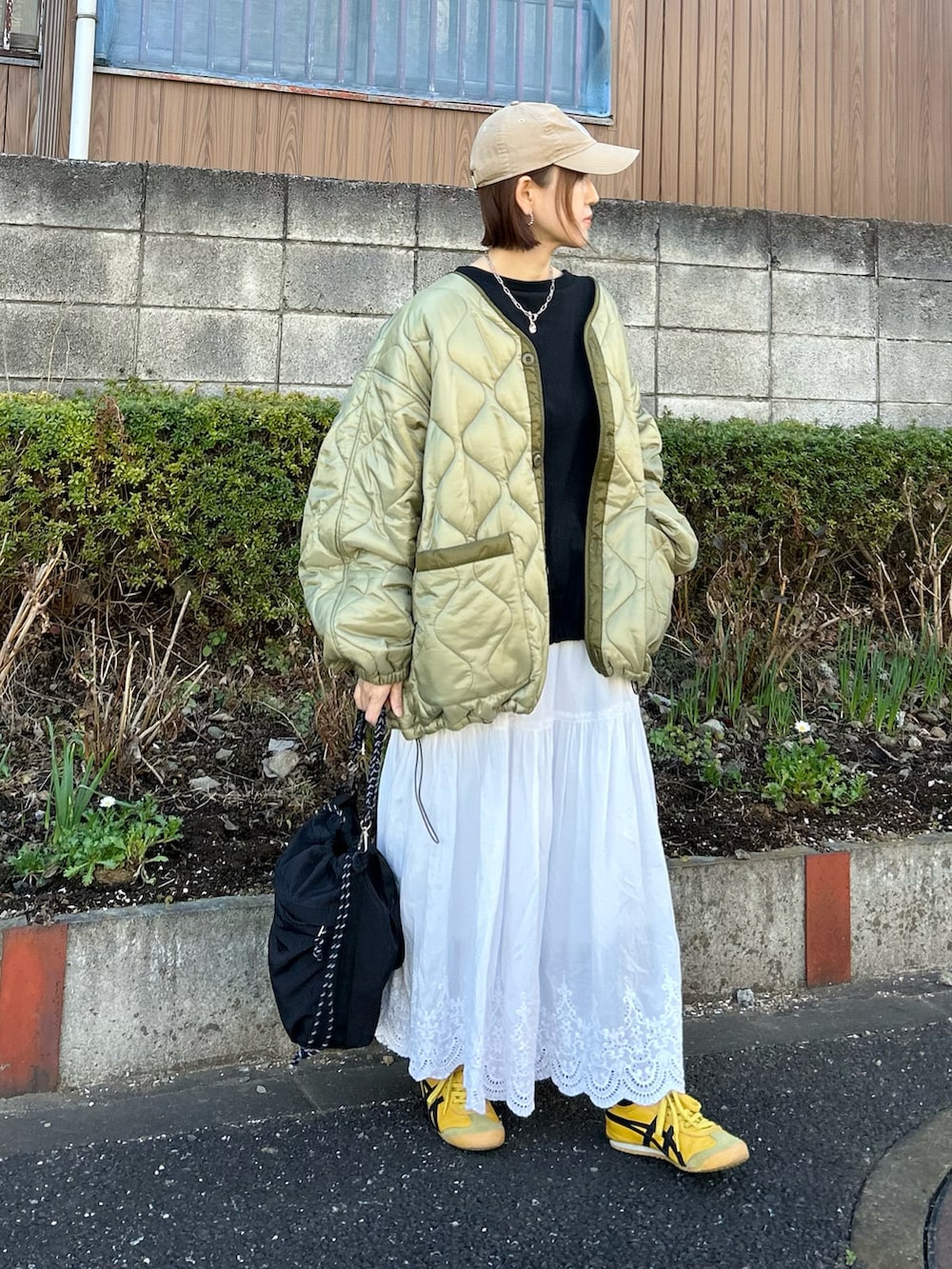 グリーン系のブルゾン、ブラック系のTシャツ/カットソー、ブラック系のトートバッグを着用したレディースの冬コーディネートの5枚目の写真