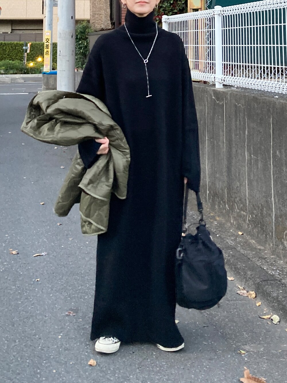 ブラック系のワンピース、ブラック系のショルダーバッグ、その他のスニーカーを着用したレディースの冬コーディネートの3枚目の写真