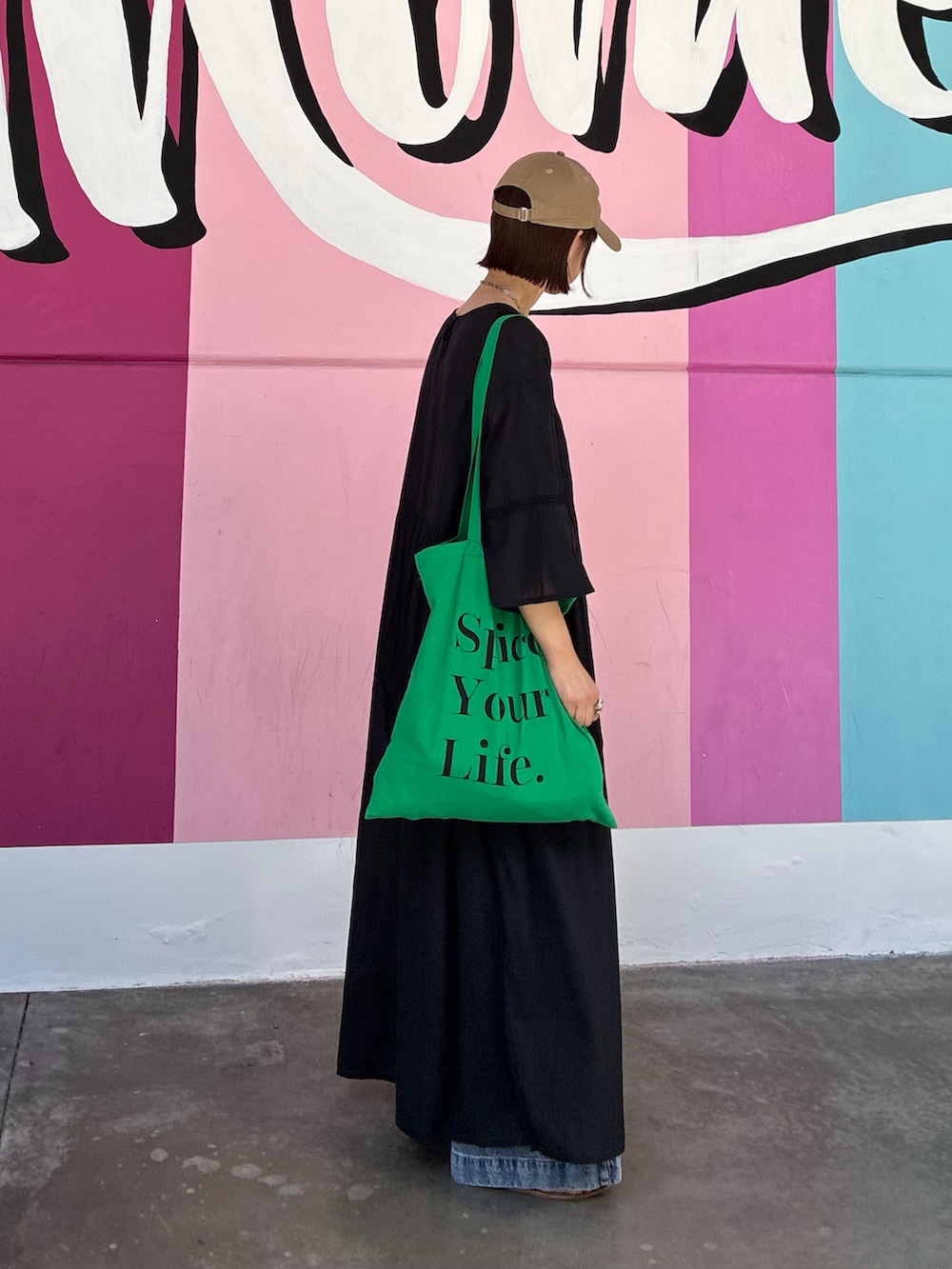 ブラック系のワンピースを着用したレディースの春コーディネートの2枚目の写真