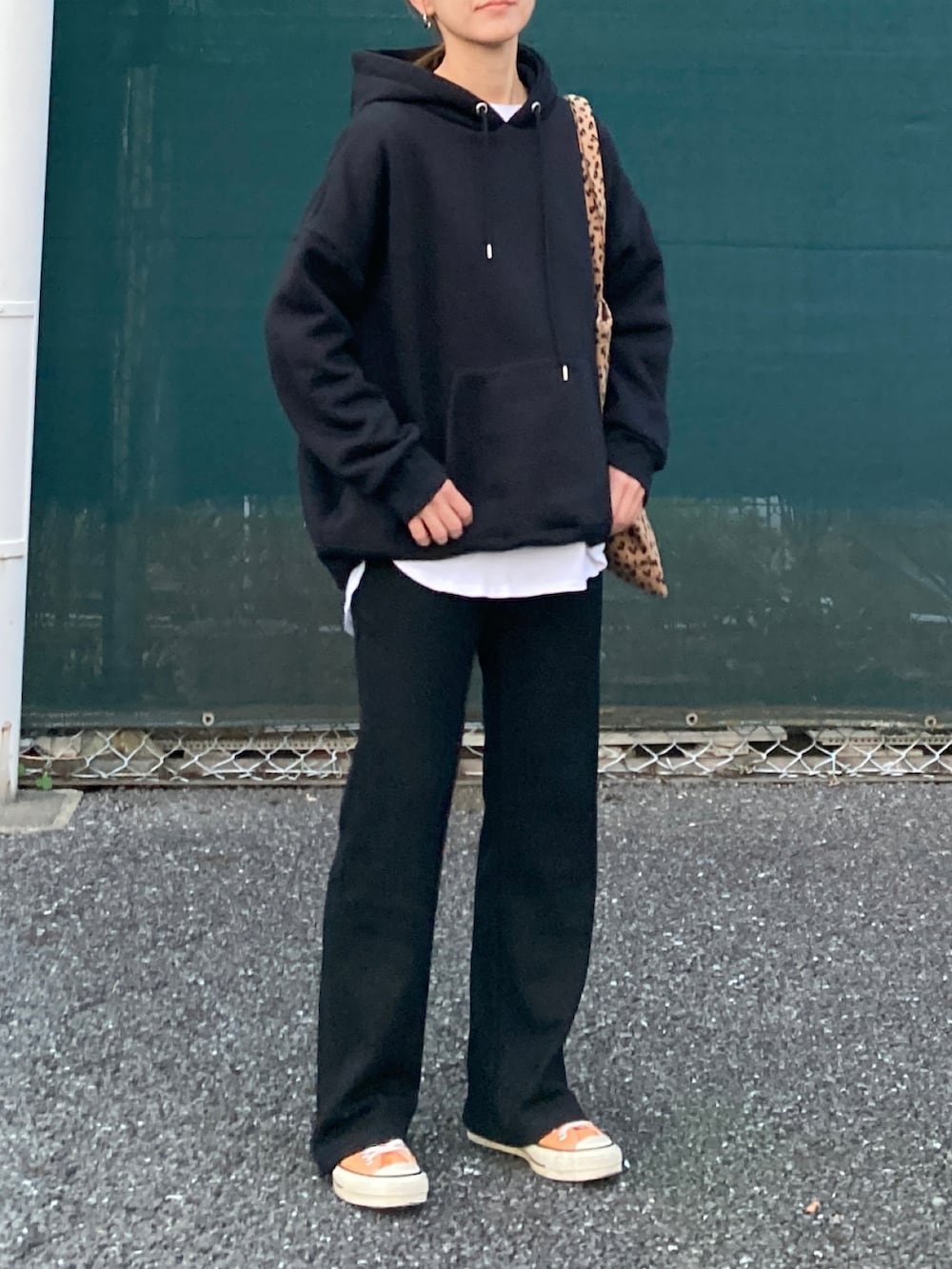 ブラック系のパーカー、ブラック系のその他パンツ、イエロー系のトートバッグを着用したレディースの秋コーディネートの2枚目の写真