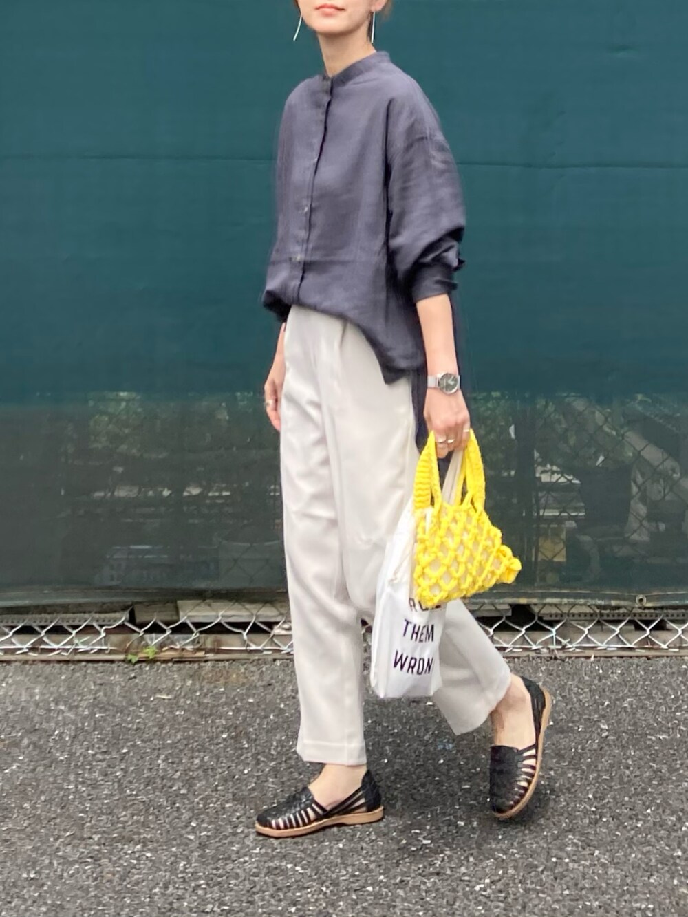 グレー系のシャツ/ブラウス、ホワイト系のスラックス、イエロー系のハンドバッグを着用したレディースの春コーディネートの4枚目の写真