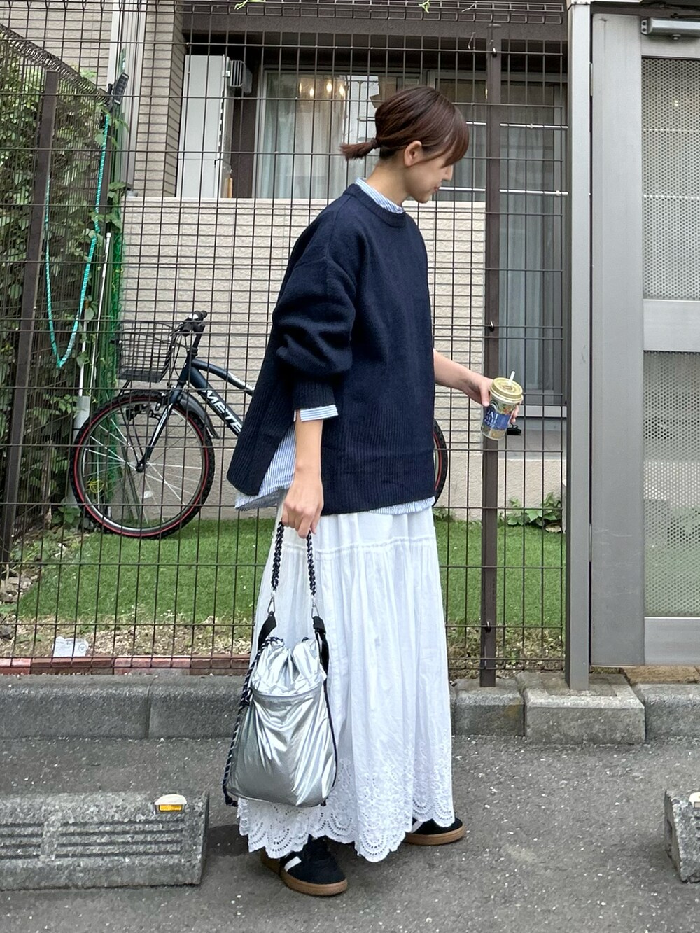 ブルー系のニット/セーター、シルバー系のショルダーバッグ、ホワイト系のスカートを着用したレディースの秋コーディネートの2枚目の写真