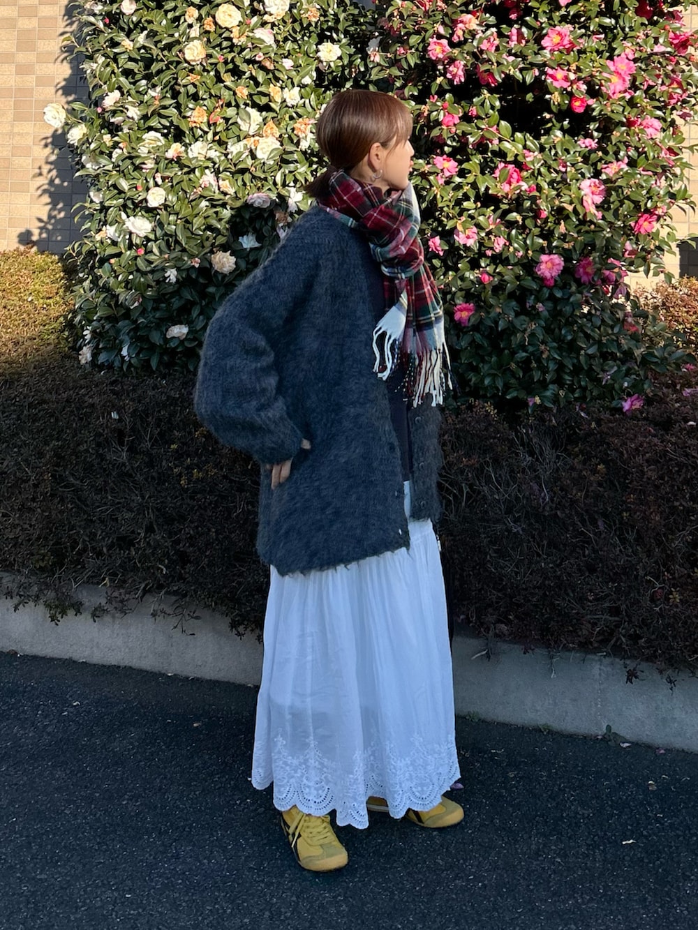 グレー系のTシャツ/カットソー、ホワイト系のスカート、グレー系のカーディガン/ボレロを着用したレディースの冬コーディネートの3枚目の写真