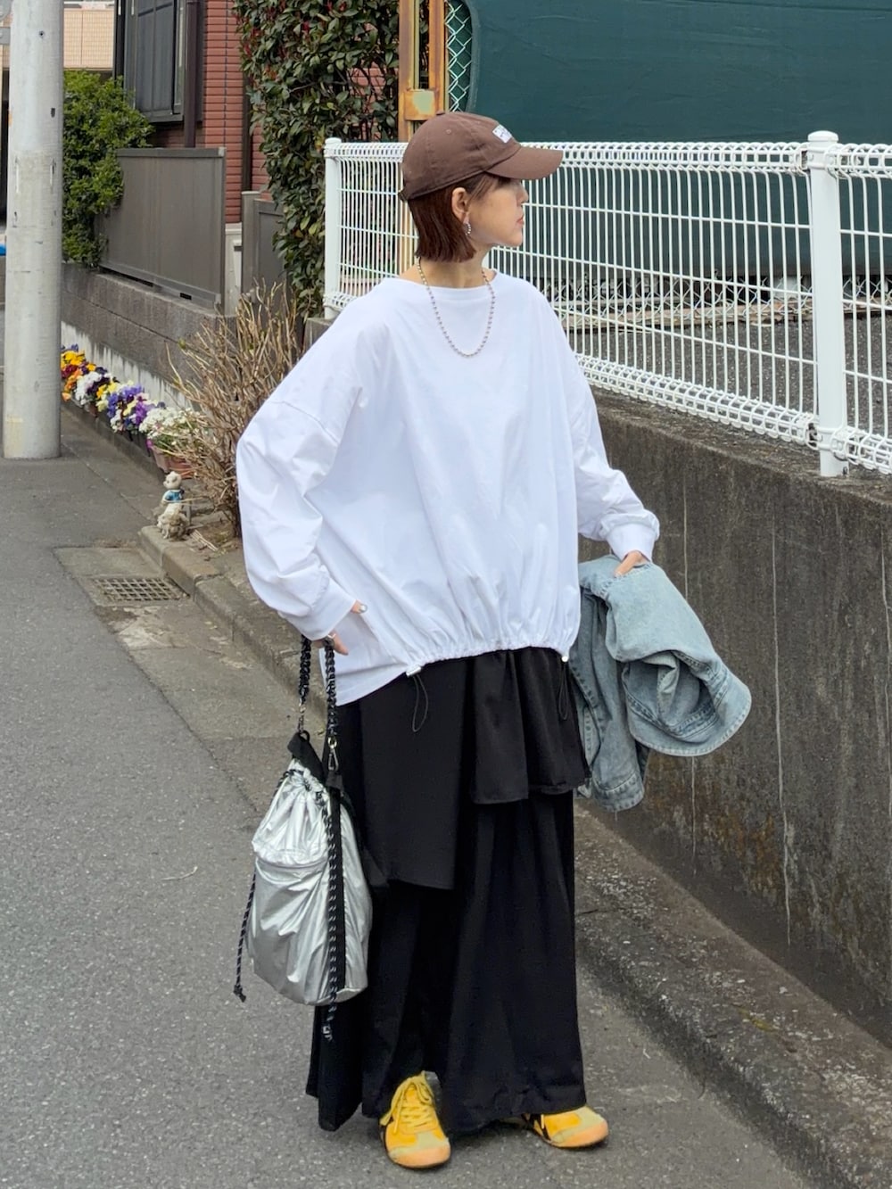 ホワイト系のTシャツ/カットソー、ブラック系のスカート、シルバー系のトートバッグを着用したレディースの春コーディネートの3枚目の写真