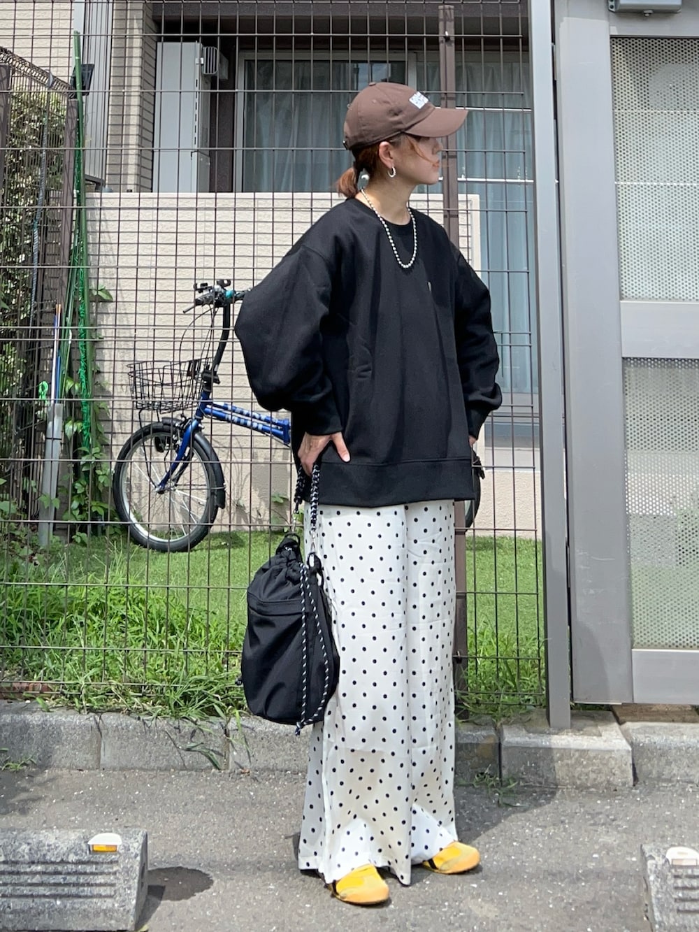 ブラック系のスウェット、ホワイト系のスラックス、ブラック系のトートバッグを着用したレディースの秋コーディネートの3枚目の写真