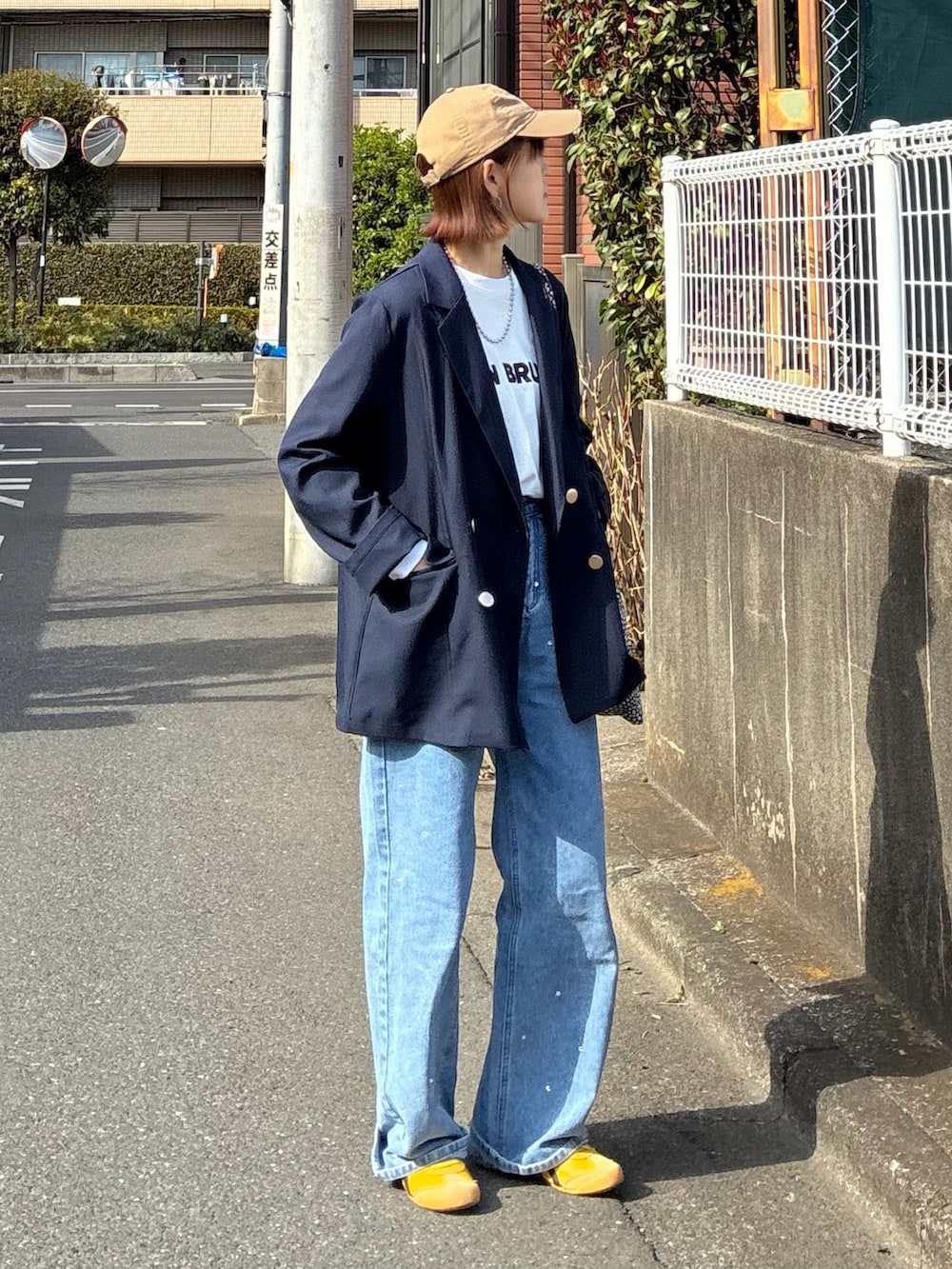 ブルー系のテーラードジャケット、ホワイト系のTシャツ/カットソー、ブルー系のデニムパンツを着用したレディースの春コーディネートの2枚目の写真