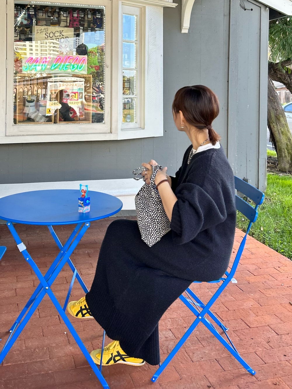 ブラック系のワンピース、グリーン系のノーカラージャケット、ブラック系のトートバッグを着用したレディースの冬コーディネートの4枚目の写真