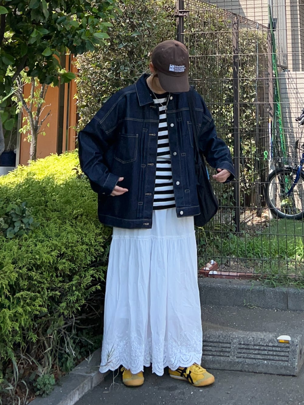 ブラック系のTシャツ/カットソー、ブルー系のデニムジャケット、ブラック系のトートバッグを着用したレディースの秋コーディネートの4枚目の写真