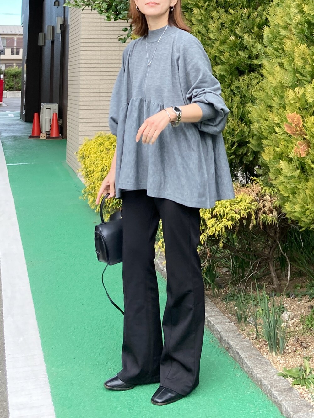 グレー系のニット/セーター、ブラック系のその他パンツ、ブラック系のブーツを着用したレディースの冬コーディネートの2枚目の写真