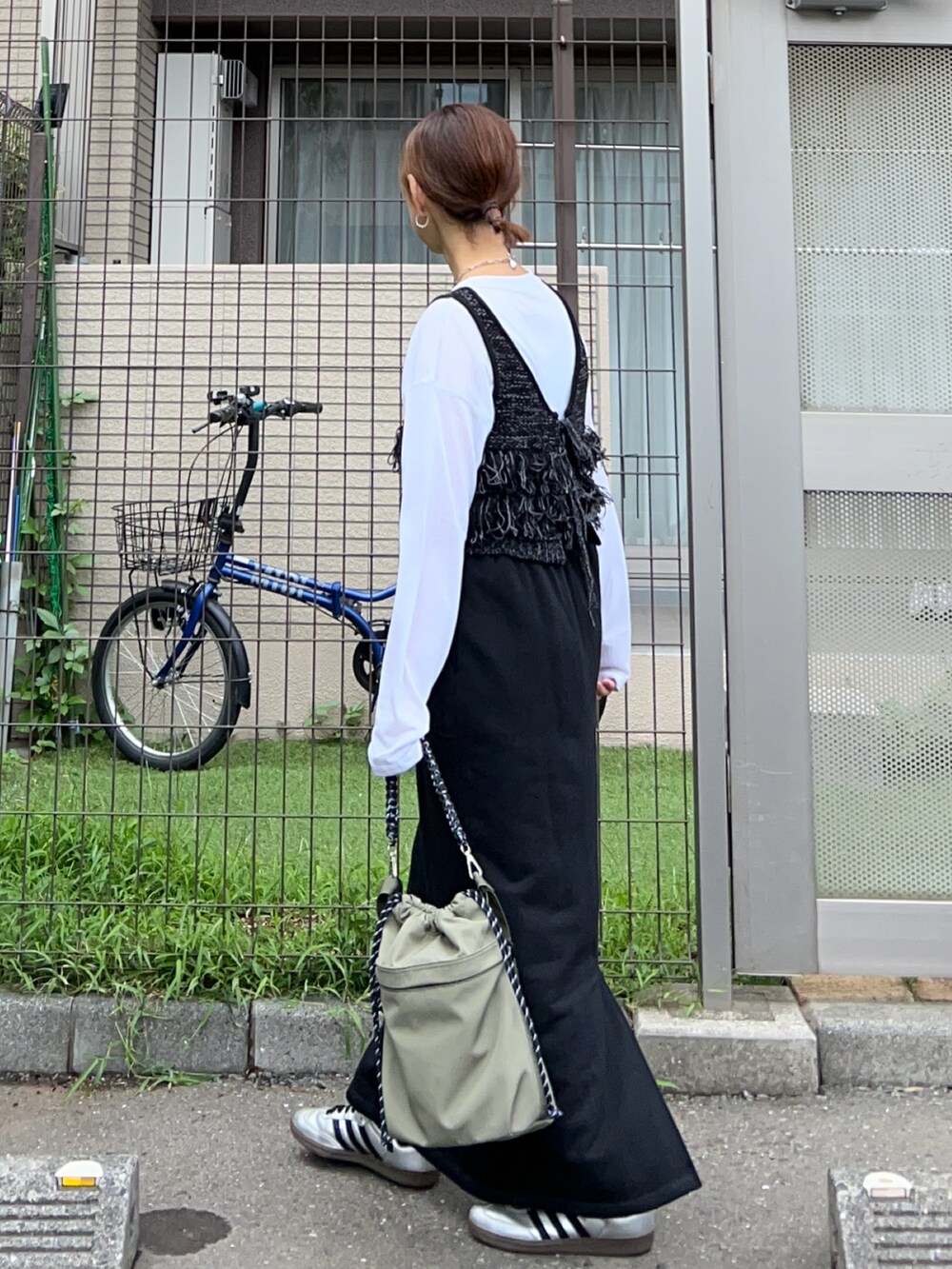 ブラック系のベスト、ホワイト系のTシャツ/カットソー、ブラック系のスカートを着用したレディースの秋コーディネートの3枚目の写真
