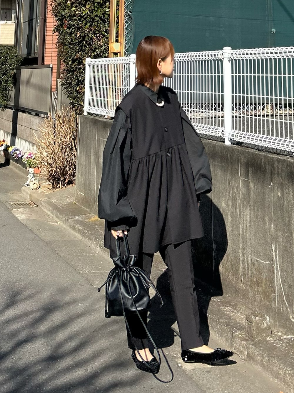 ブラック系のスーツセット、ブラック系のシャツ/ブラウス、ブラック系のショルダーバッグを着用したレディースの冬コーディネートの2枚目の写真