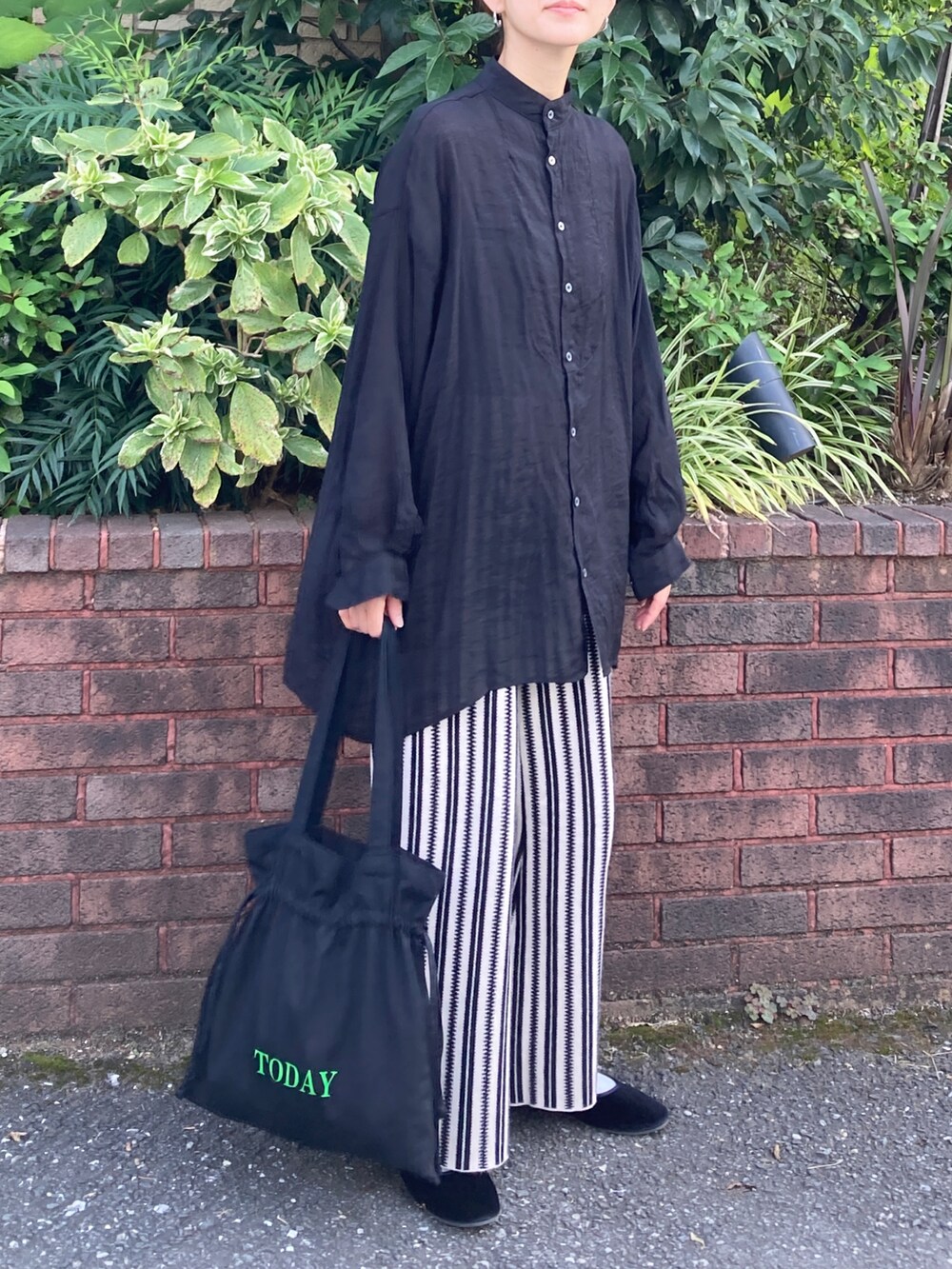 ブラック系のシャツ/ブラウス、グレー系のその他パンツ、ブラック系のトートバッグを着用したレディースの秋コーディネートの2枚目の写真