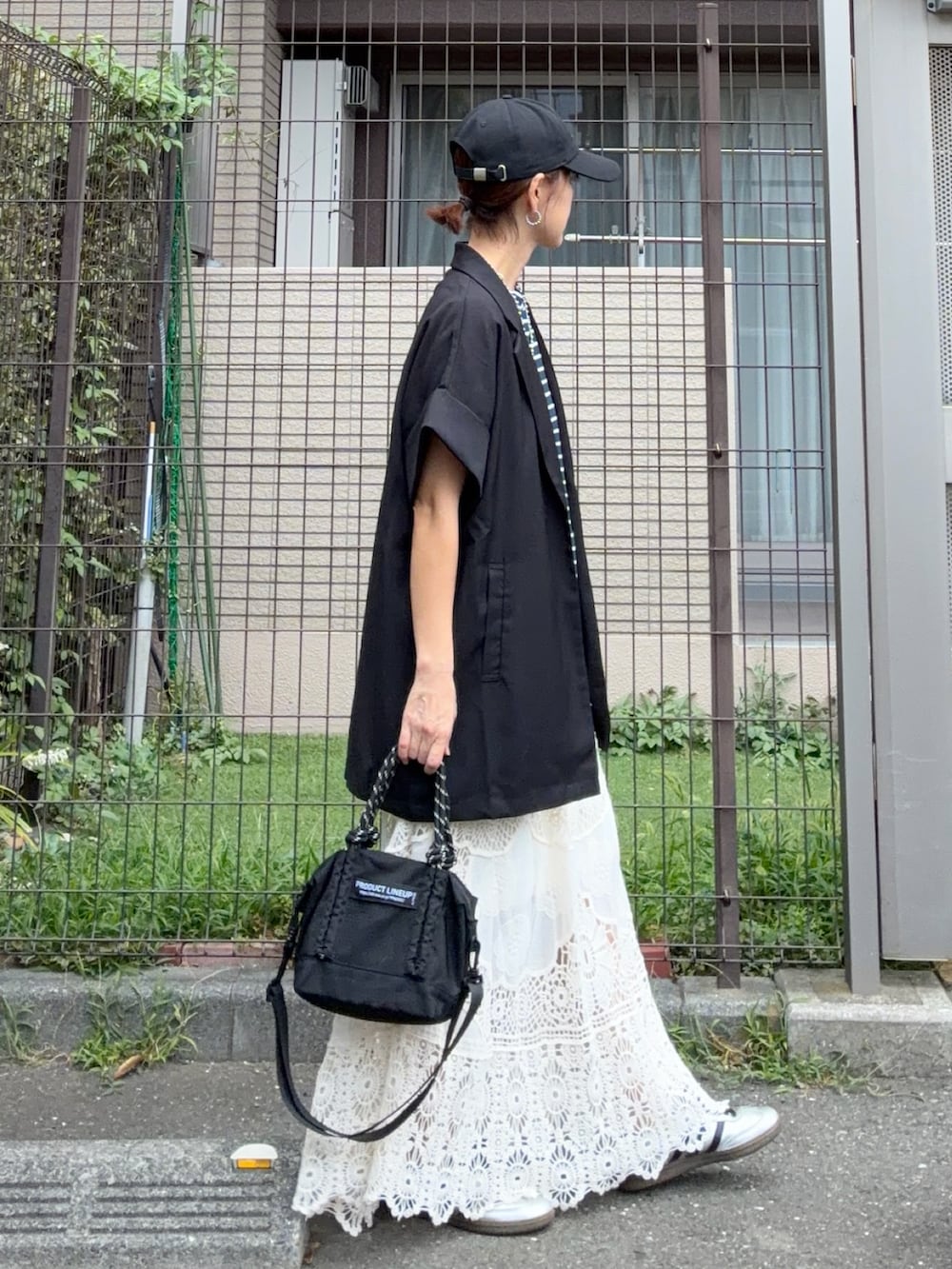 ブルー系のTシャツ/カットソー、ブラック系のテーラードジャケット、ホワイト系のスカートを着用したレディースの秋コーディネートの2枚目の写真