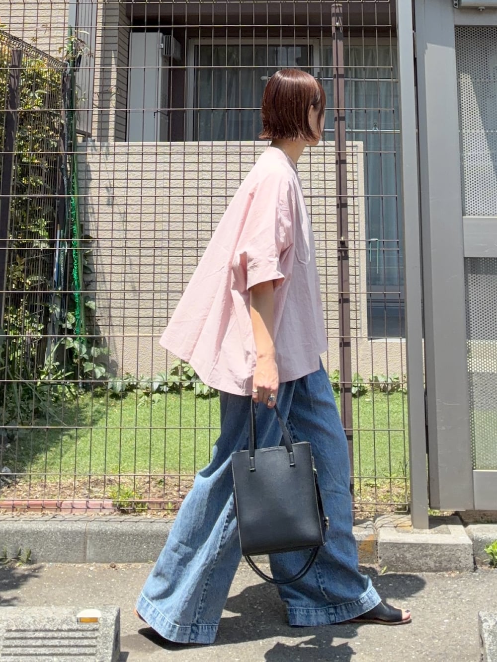 ピンク系のシャツ/ブラウス、ブルー系のデニムパンツ、ブラック系のショルダーバッグを着用したレディースの春コーディネートの3枚目の写真