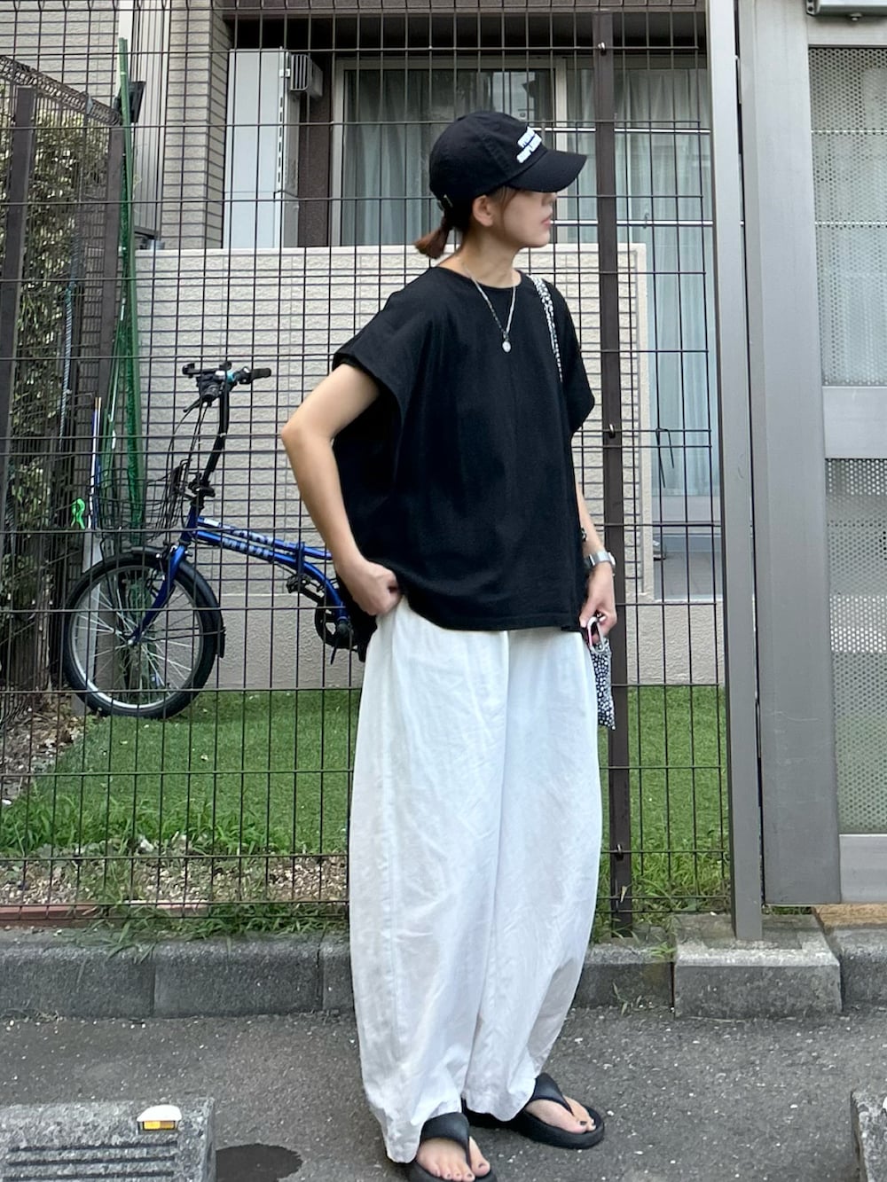 ブラック系のTシャツ/カットソー、ホワイト系のその他パンツ、ブラック系のキャップを着用したレディースの秋コーディネートの2枚目の写真