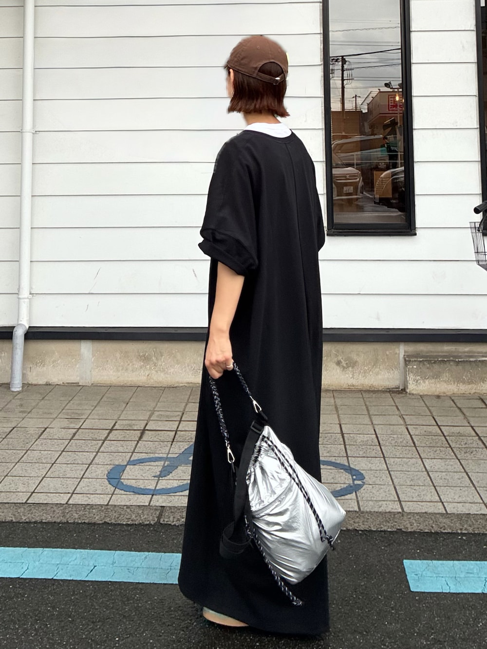 ブラック系のワンピース、シルバー系のショルダーバッグ、ブルー系のスニーカーを着用したレディースの秋コーディネートの4枚目の写真