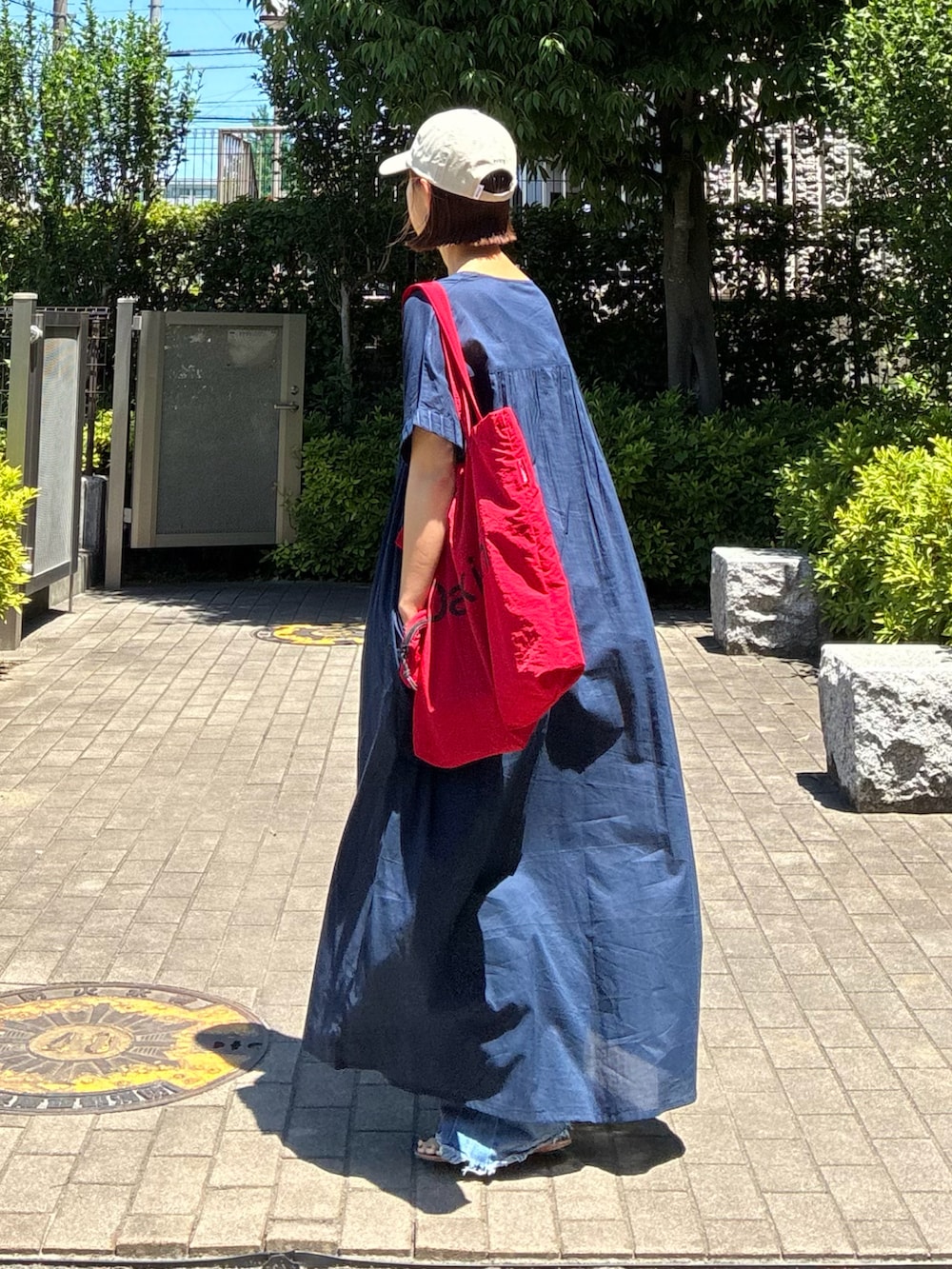 ブルー系のデニムパンツ、レッド系のトートバッグ、ブルー系のワンピースを着用したレディースの夏コーディネートの4枚目の写真