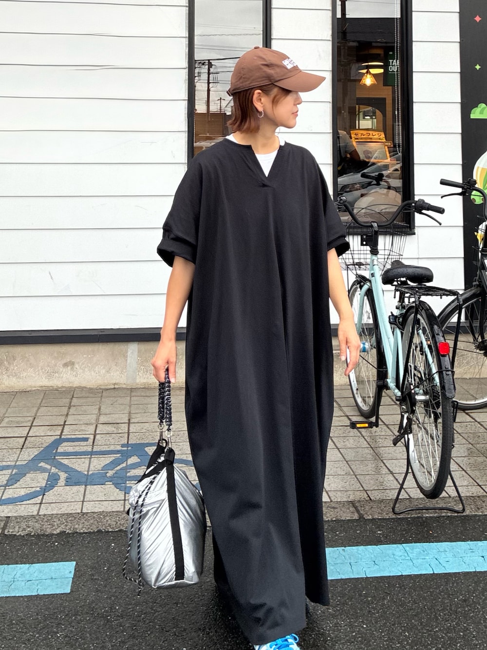 ブラック系のワンピース、シルバー系のショルダーバッグ、ブルー系のスニーカーを着用したレディースの秋コーディネートの2枚目の写真