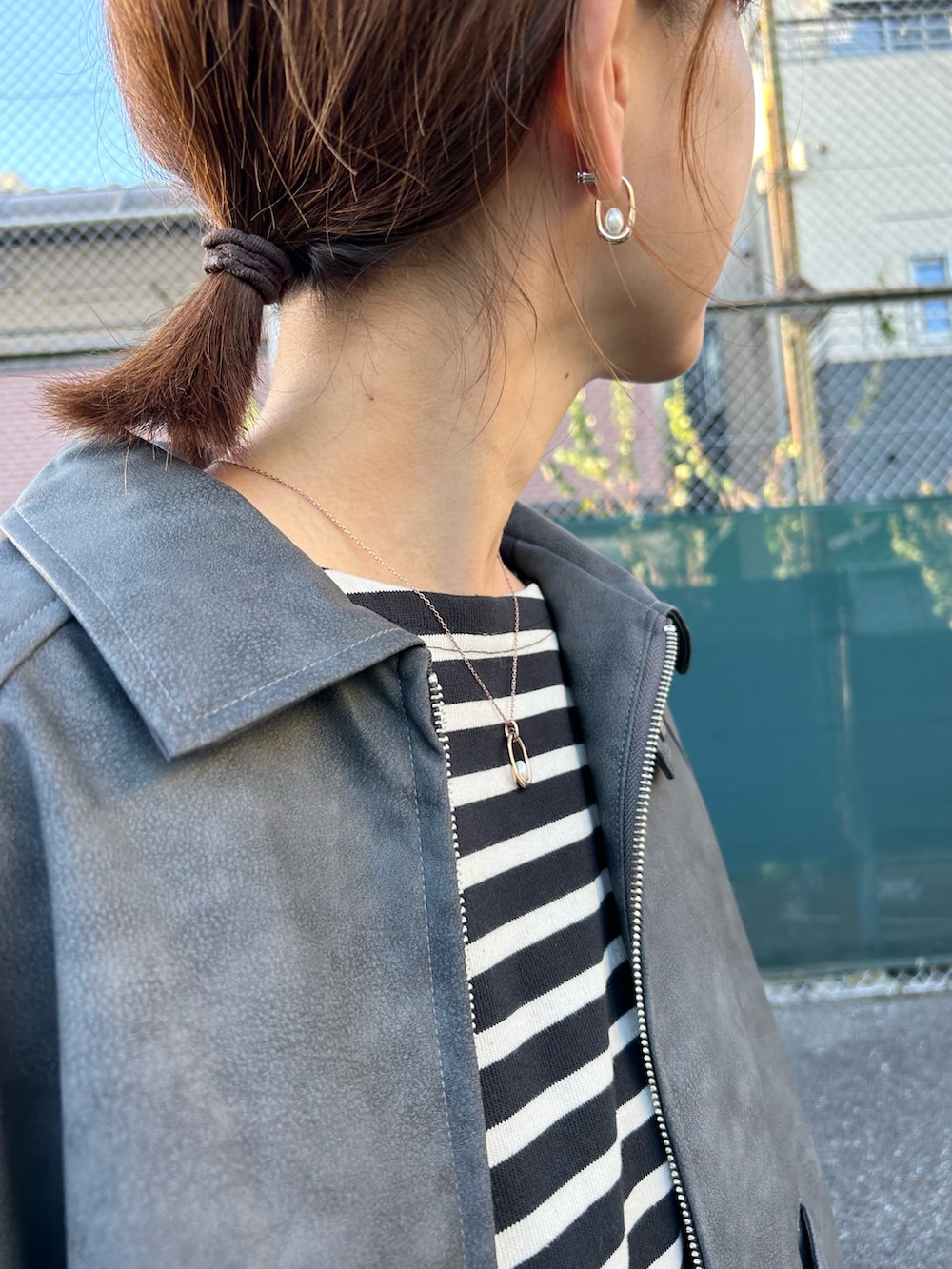 ブラック系のブルゾン、ブラック系のトートバッグ、ホワイト系のスカートを着用したレディースの秋コーディネートの3枚目の写真