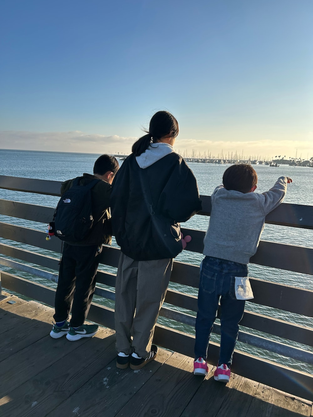 グリーン系のノーカラージャケット、グレー系のワンピース、シルバー系のトートバッグを着用したレディースの冬コーディネートの5枚目の写真