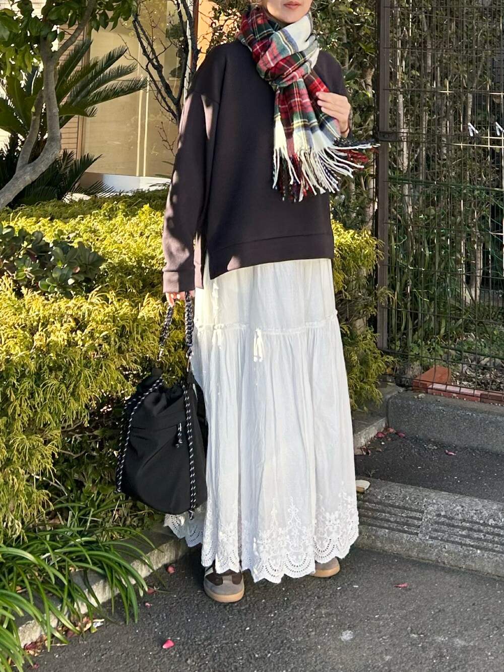 グレー系のTシャツ/カットソー、ホワイト系のスカート、ブラック系のトートバッグを着用したレディースの冬コーディネートの5枚目の写真