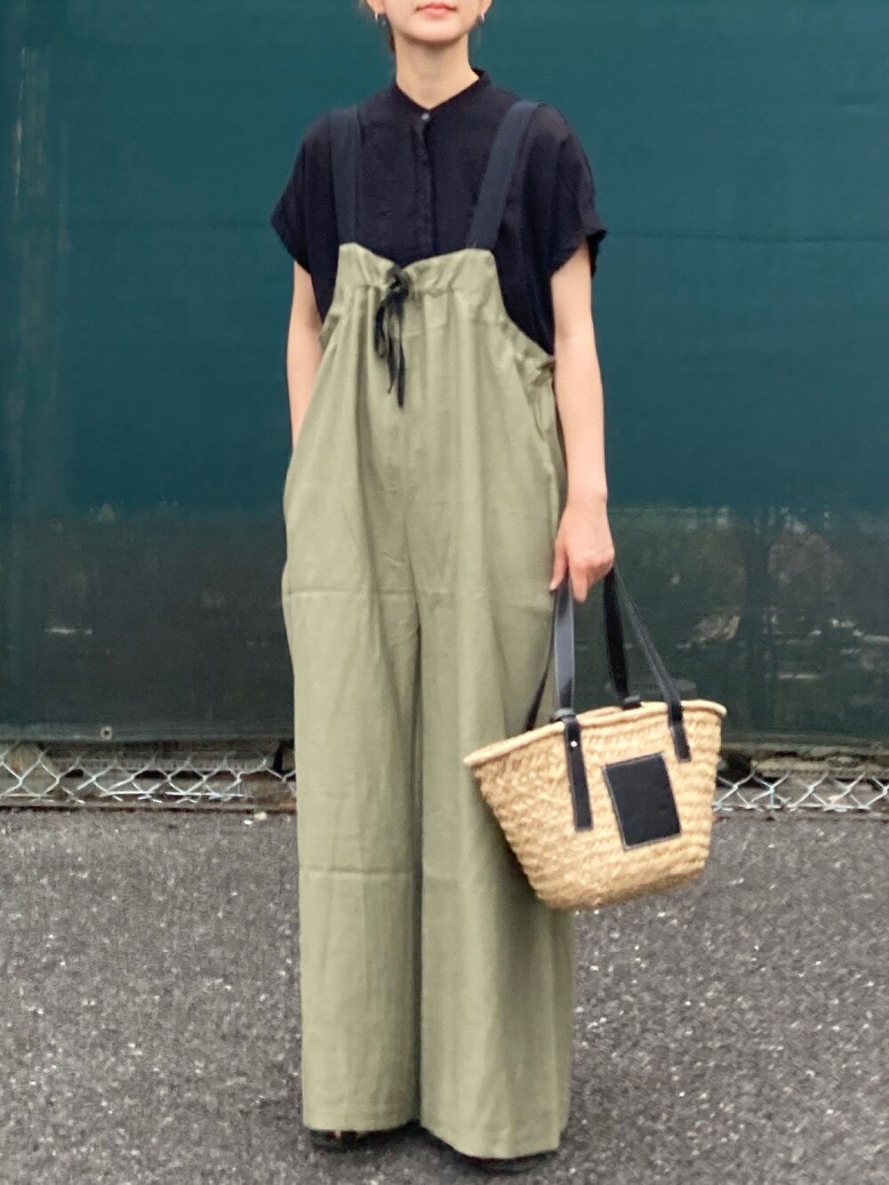 ブラック系のシャツ/ブラウス、グリーン系のサロペット/オーバーオール、ブラック系のかごバッグを着用したレディースの夏コーディネートの2枚目の写真